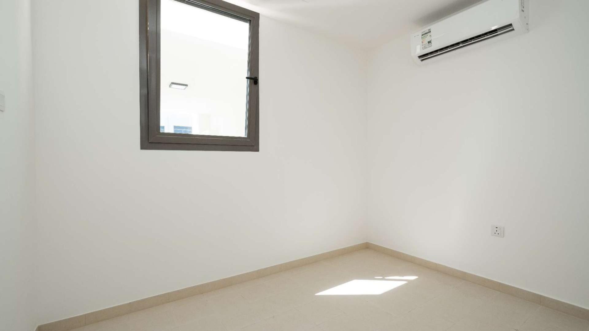 Empty room with sliding glass doors in Noor Townhouse, Town Square