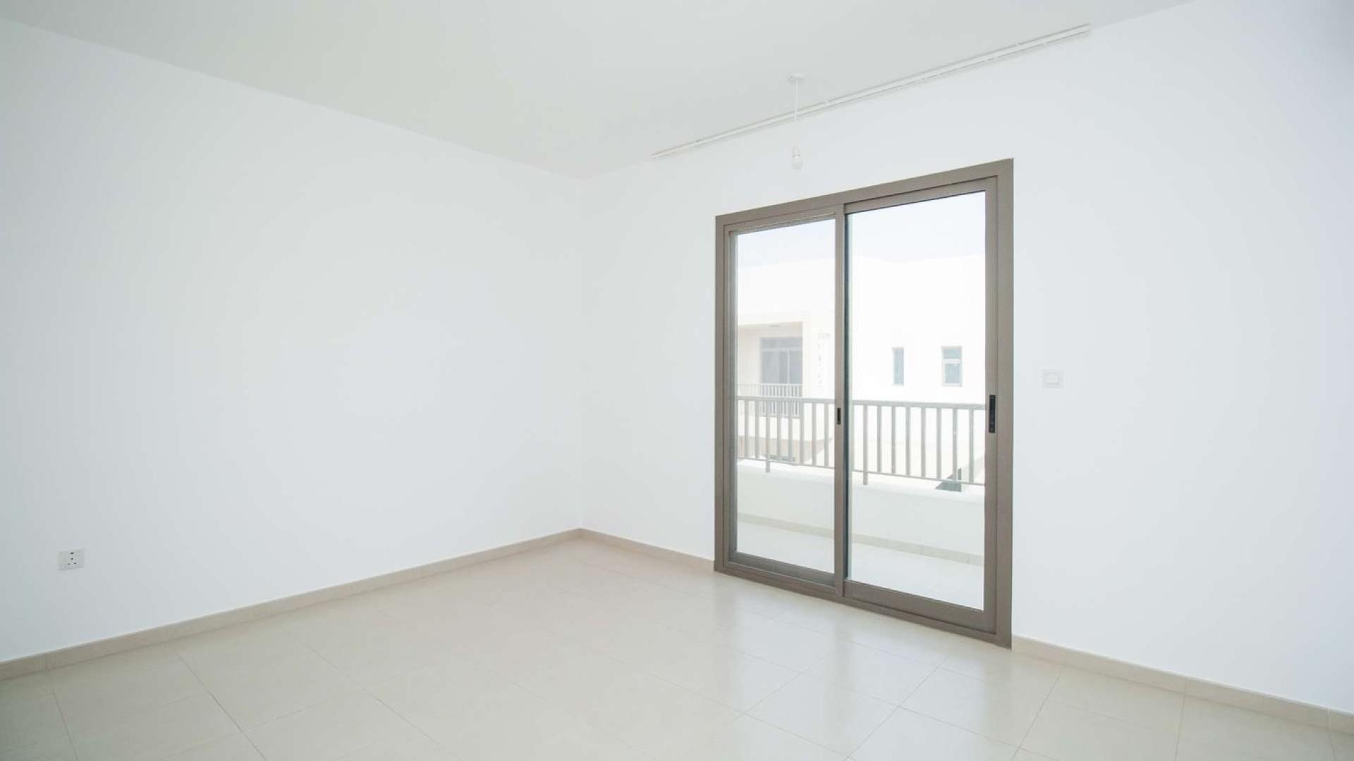 Empty room with sliding glass door in Hayat Townhouses, Town Square