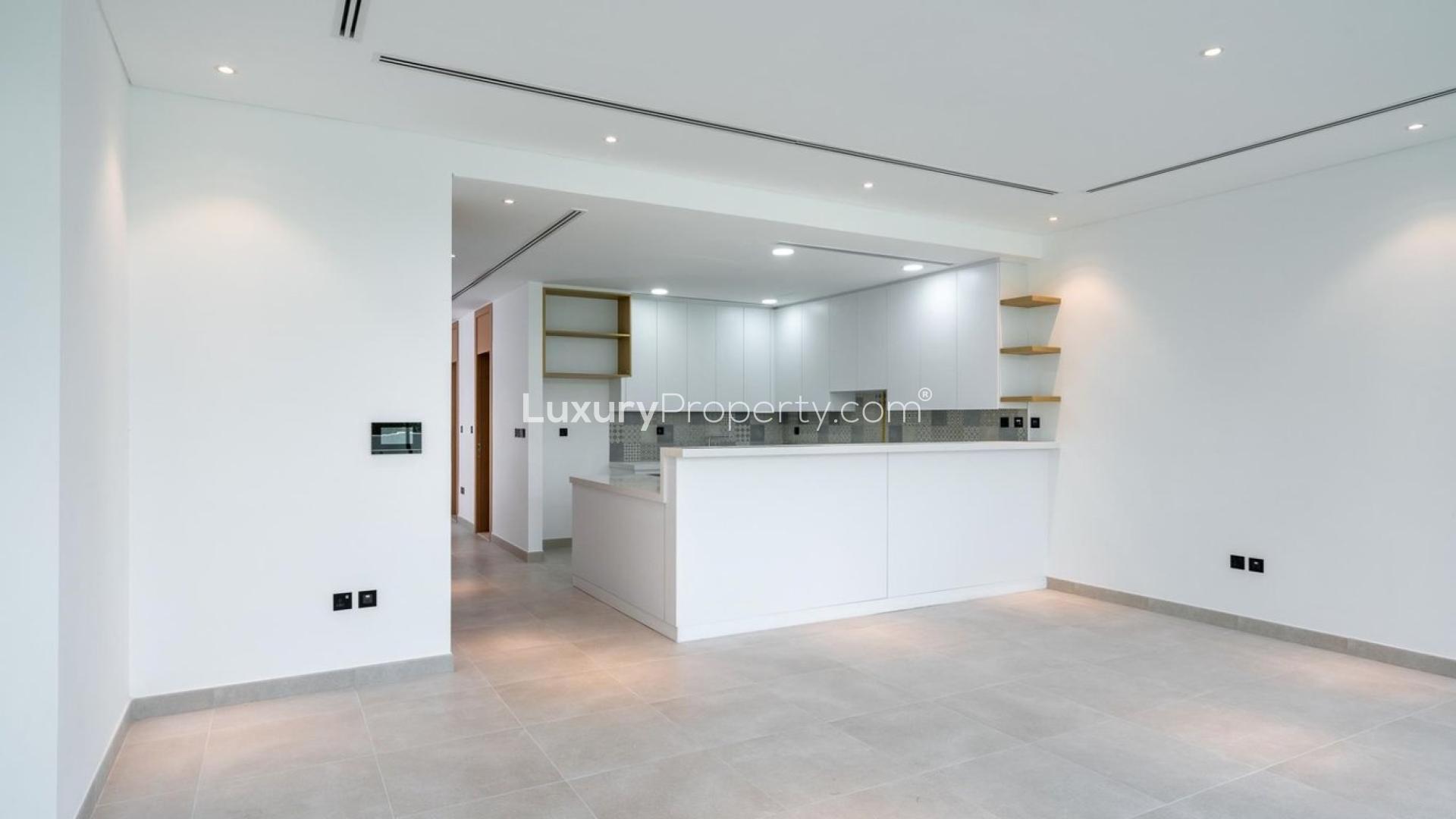 Modern kitchen in Jumeirah Golf Estates townhouse, featuring spacious design and large windows