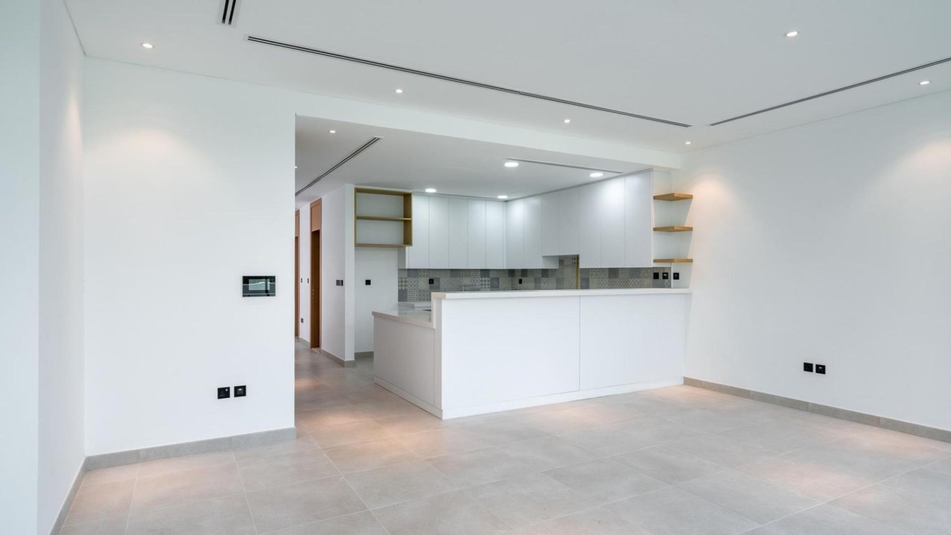 Modern kitchen in Jumeirah Golf Estates townhouse, featuring spacious design and large windows