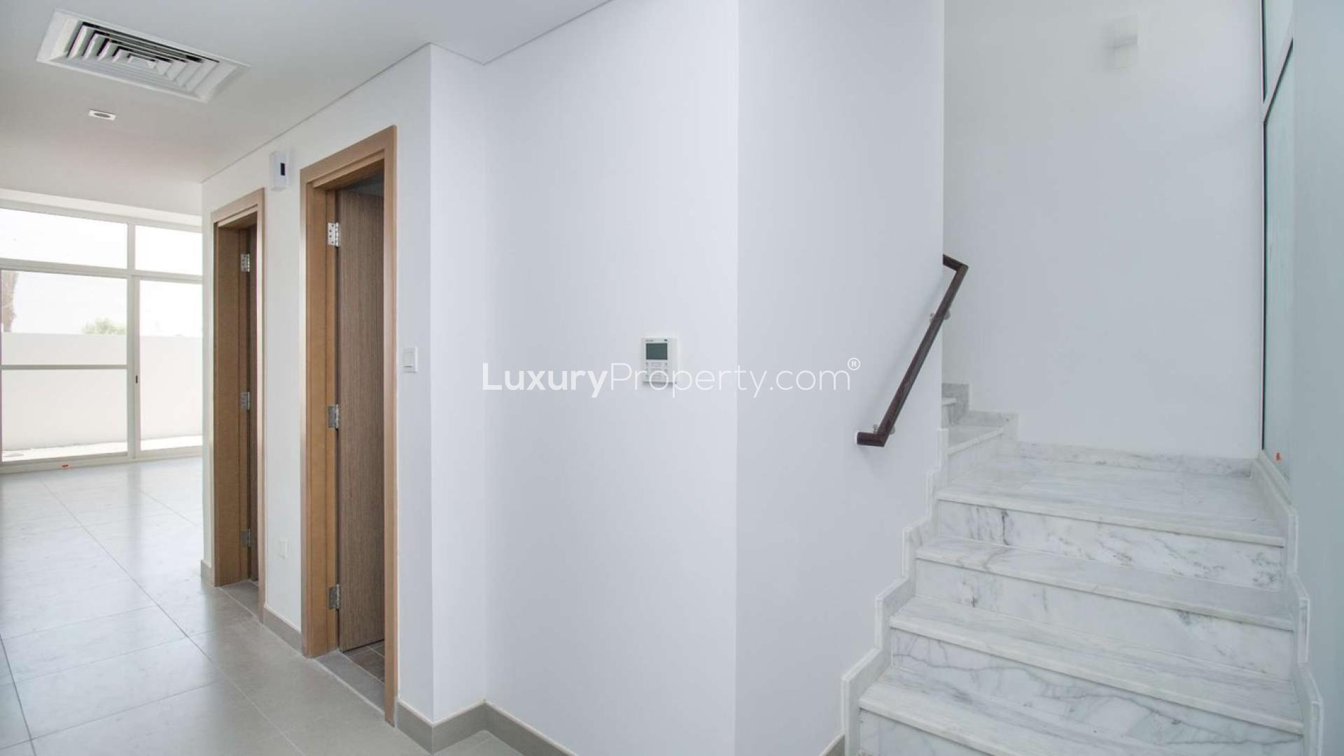 Open-plan kitchen with modern finishes in Arabella 2 townhouse, Mudon community