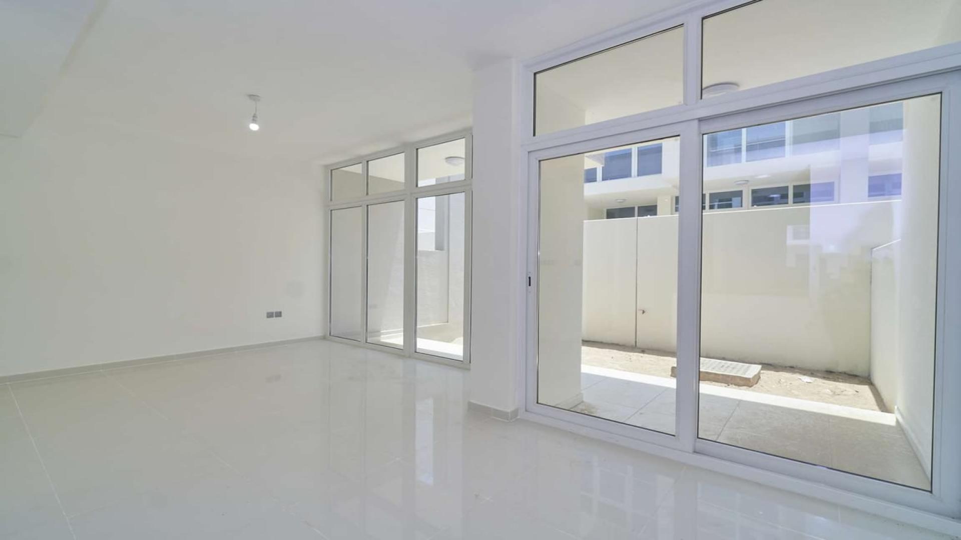 "Modern interior of 3-bedroom townhouse in Albizia, Damac Hills 2, available for sale.",Bright living area with large windows in Albizia townhouse, Damac Hills 2