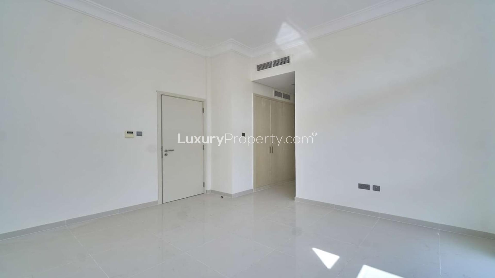 "Spacious living room with floor-to-ceiling windows in Damac Hills townhouse for sale.",Bright empty room in three-bedroom townhouse, Akoya Park, Damac Hills for sale