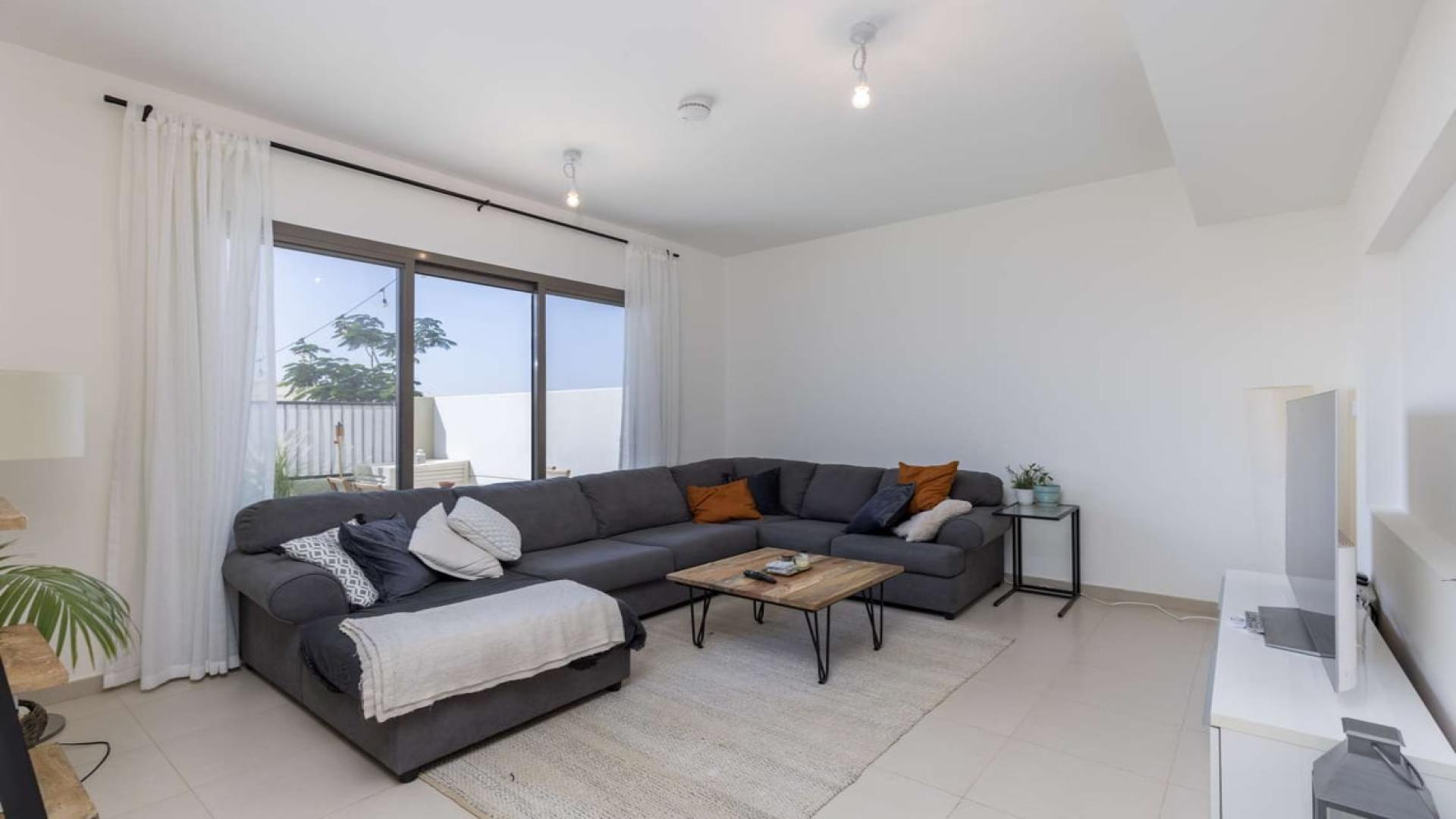 Modern living room in Noor Town Square townhouse with large windows and stylish decor