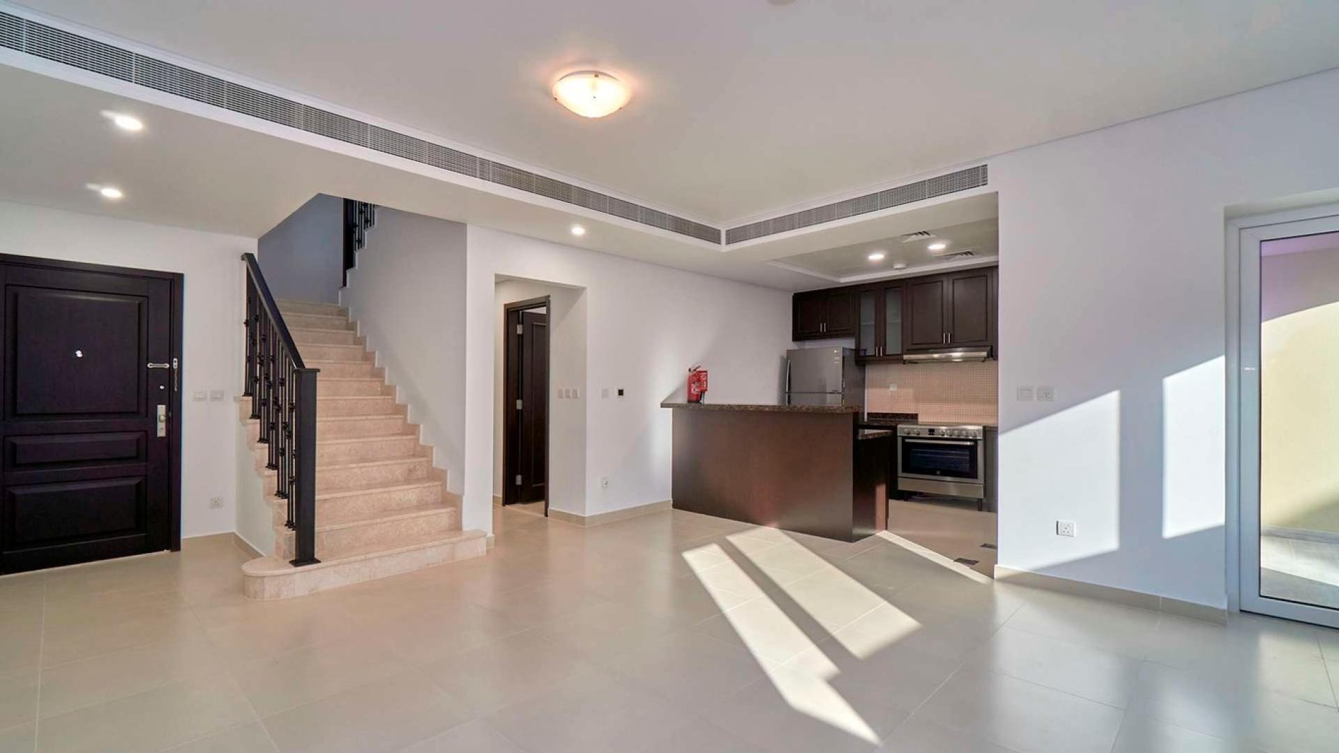 Elegant living area with staircase and modern kitchen in Casa Dora townhouse, Serena