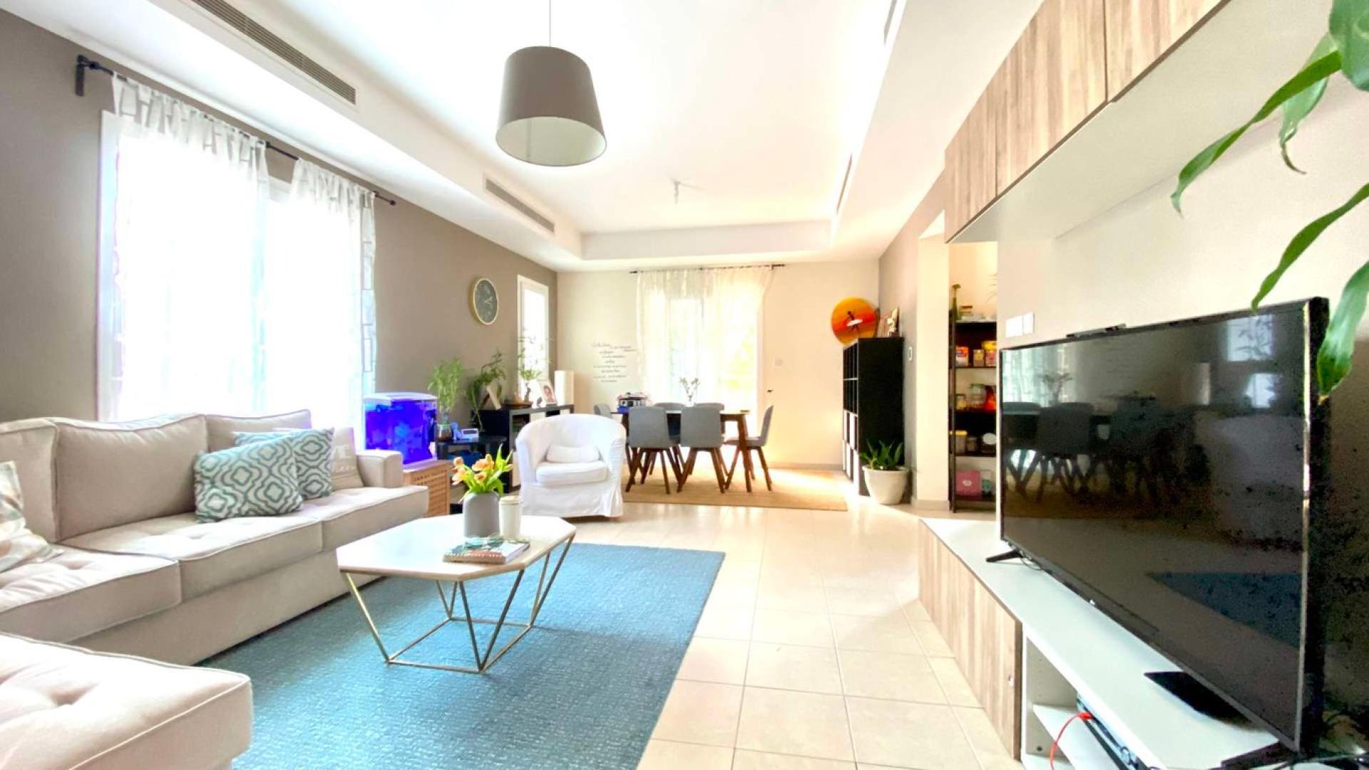 "Spacious living room in immaculate 3-bedroom townhouse, Alma, Arabian Ranches for sale.",Modern living room in 3-bedroom townhouse, Arabian Ranches, Alma community, spacious and well-lit