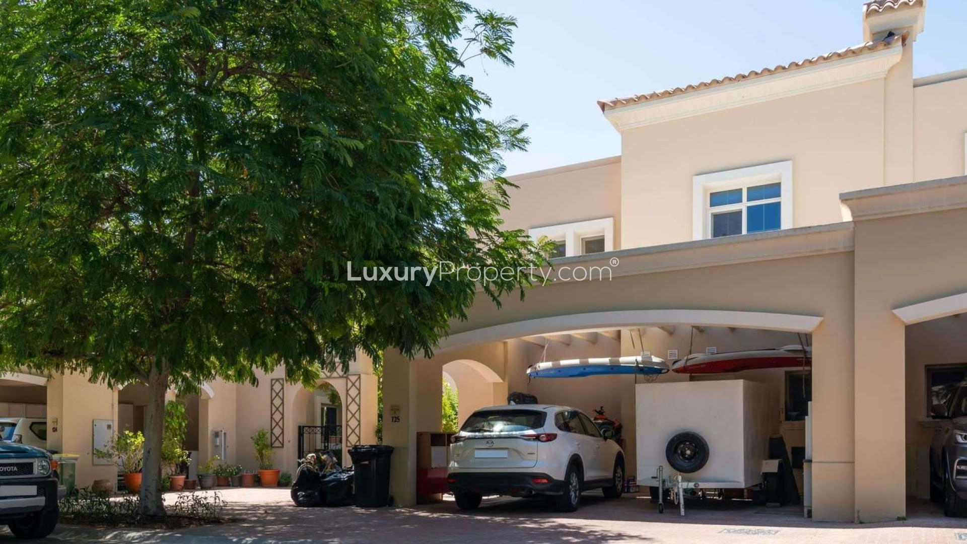 "Front view of spacious 3-bedroom villa in Alma, Arabian Ranches with carport and trees.",Kitchen in 3-bedroom Type 2E villa, Alma, Arabian Ranches, featuring modern appliances and island