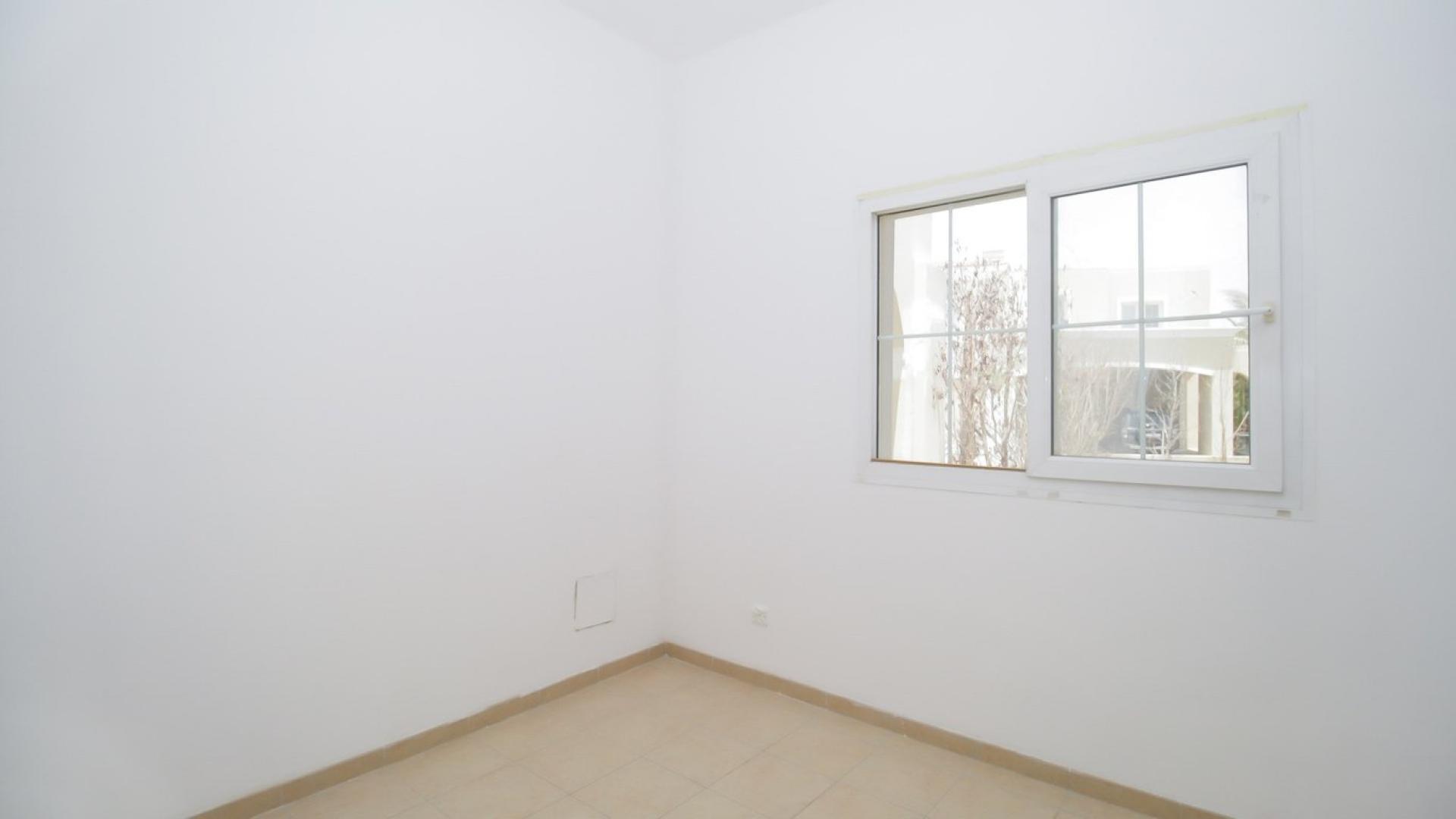 Townhouse backyard with lawn and trees in Arabian Ranches, Al Reem community