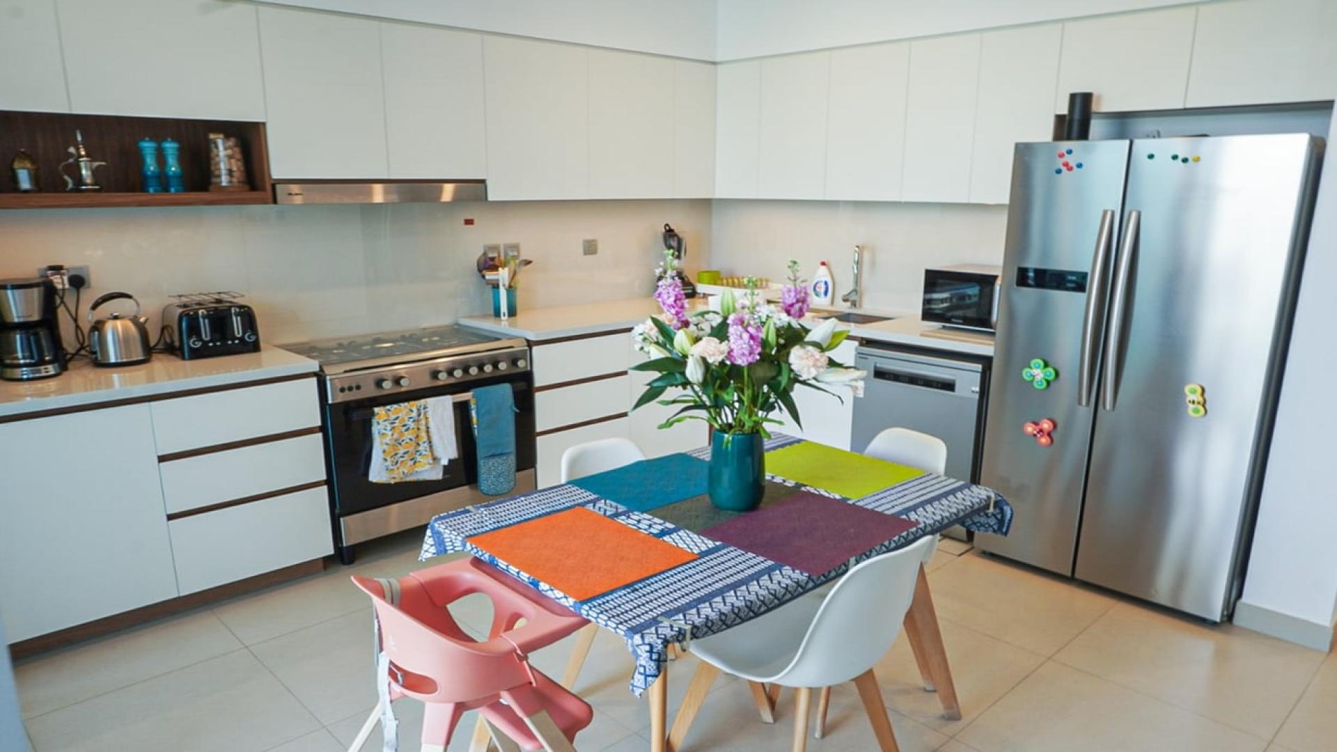 Outdoor patio with lounge chairs and artificial grass in Camelia, Arabian Ranches 2 townhouse