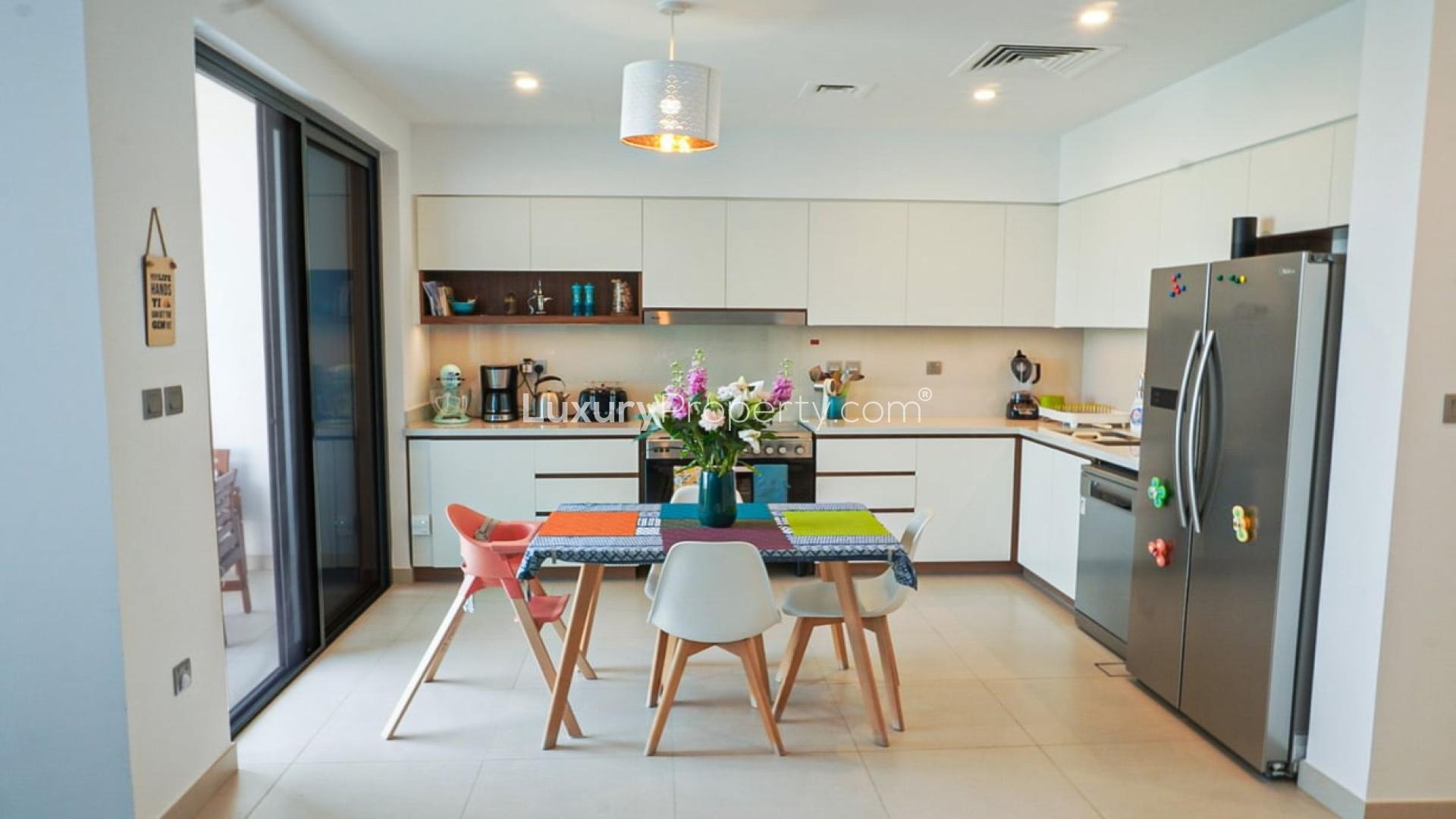 Modern townhouse backyard with patio, lawn, and lounge chairs in Arabian Ranches 2, Camelia