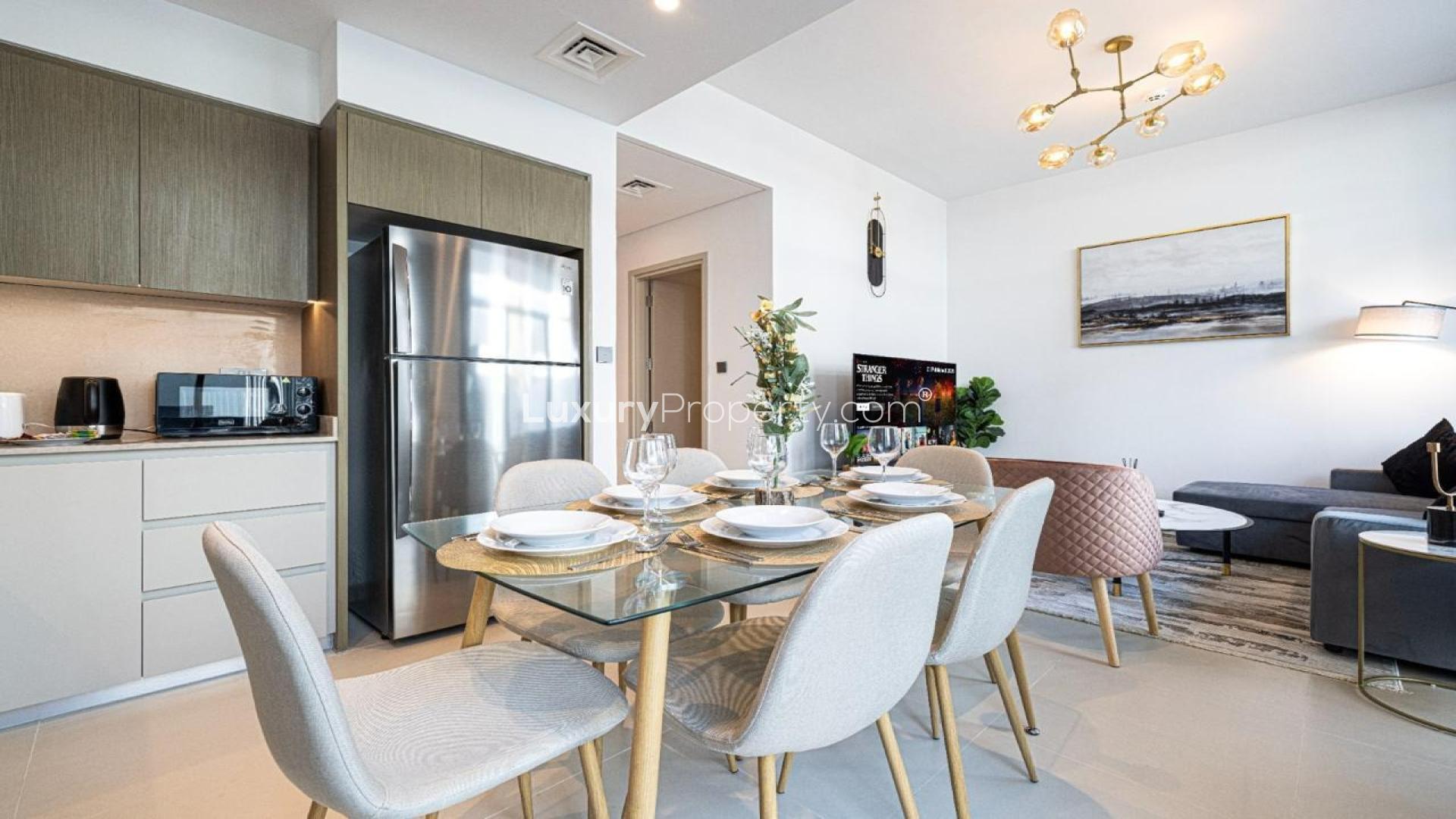 Dining area with glass table, modern decor, and garden view in Arabian Ranches 3 townhouse