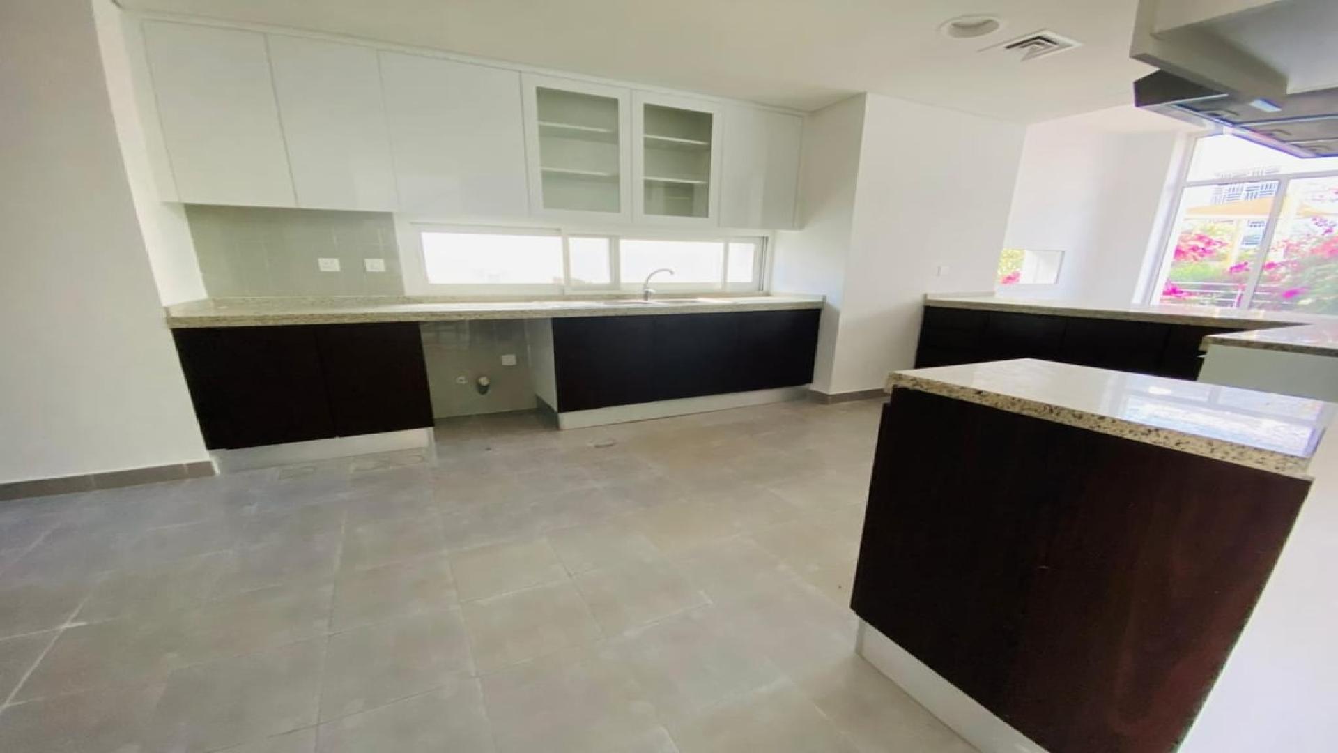 "Bright living area with garden view in Arabella Townhouse, Mudon, for sale.",Modern kitchen in Arabella Townhouses, Mudon - spacious layout with sleek cabinetry and countertops