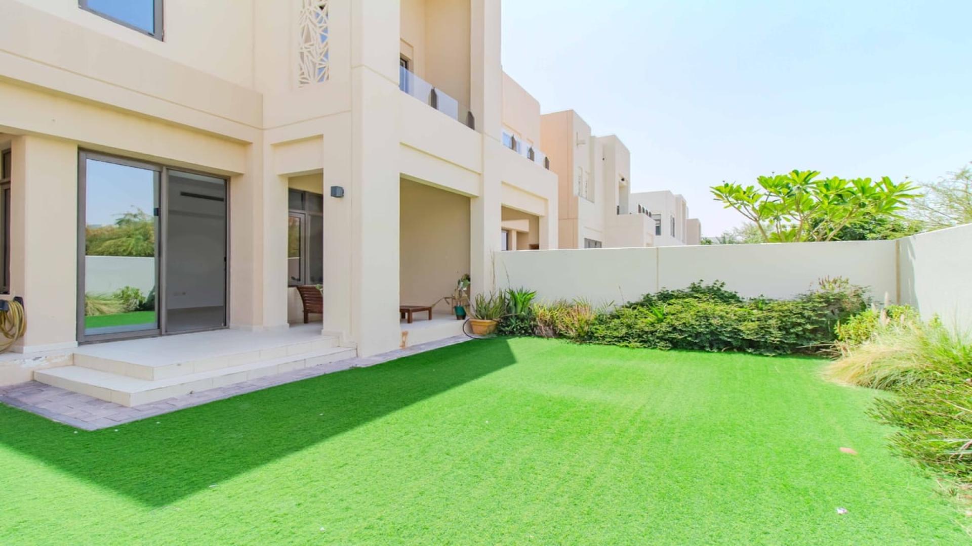 Bright living area in Mira Oasis townhouse with large windows and garden view