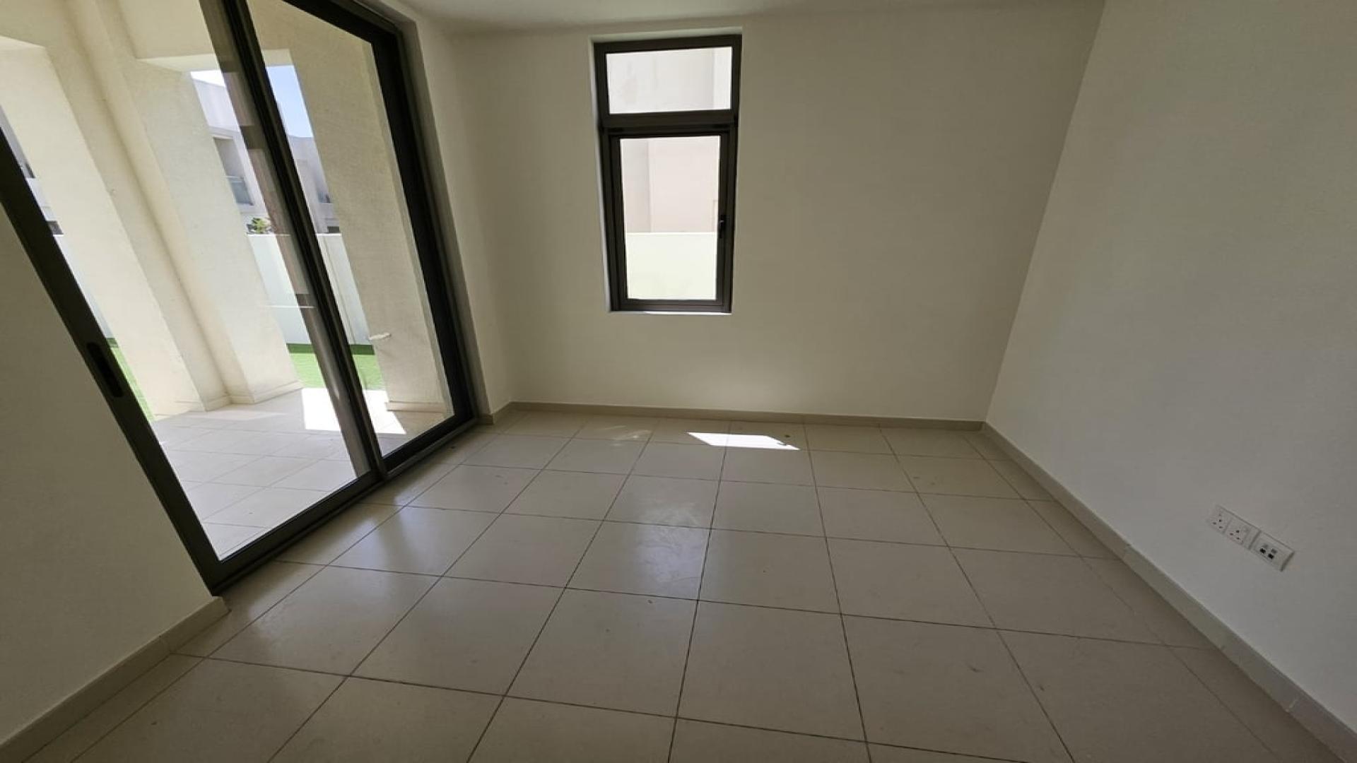 Empty room in Mira Oasis townhouse with tiled floor and large window