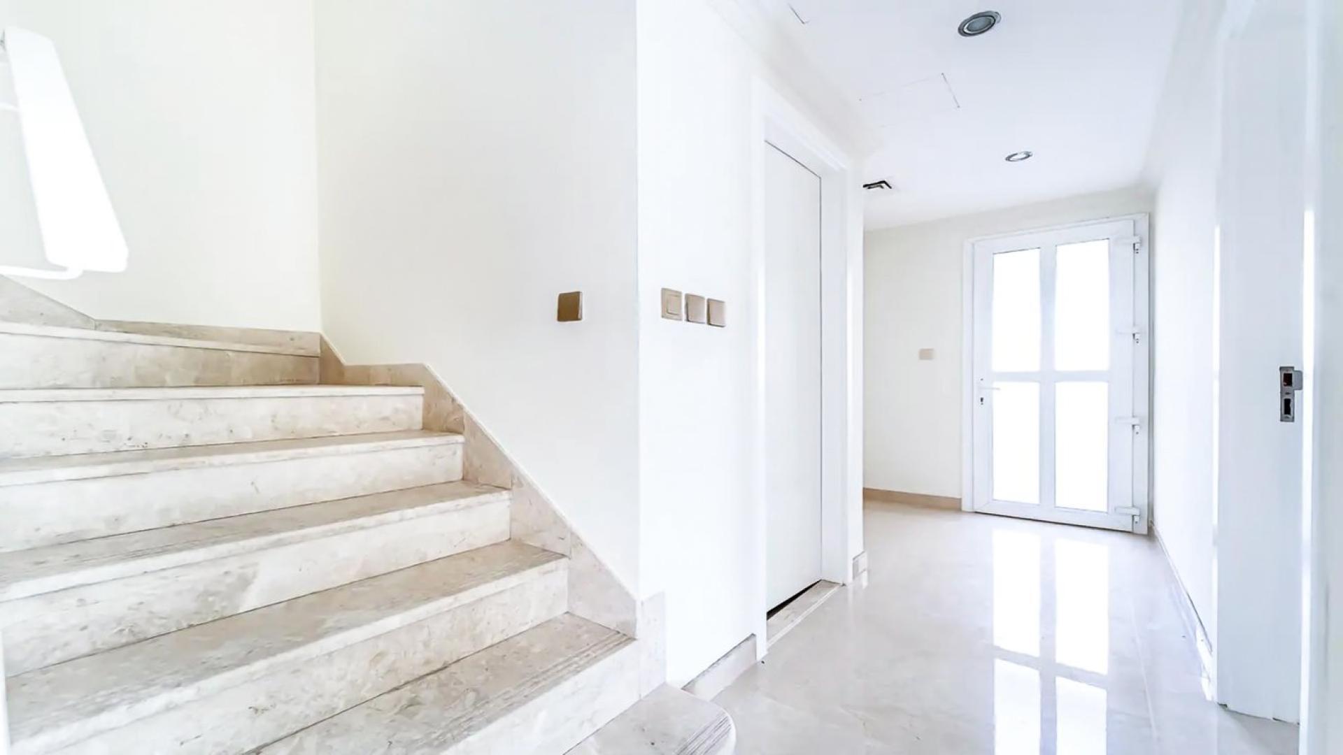 Bright empty room in Arabian Ranches 2 townhouse, featuring large windows and wooden flooring