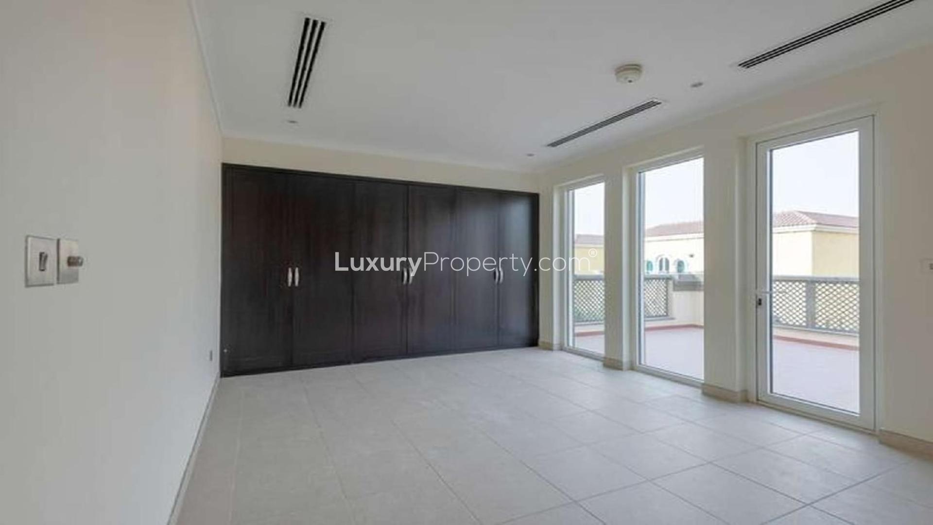 "Spacious 3-bedroom villa exterior in Jumeirah Park, Regional community, available for rent.",Spacious bedroom with large windows and built-in wardrobe in Jumeirah Park villa for rent