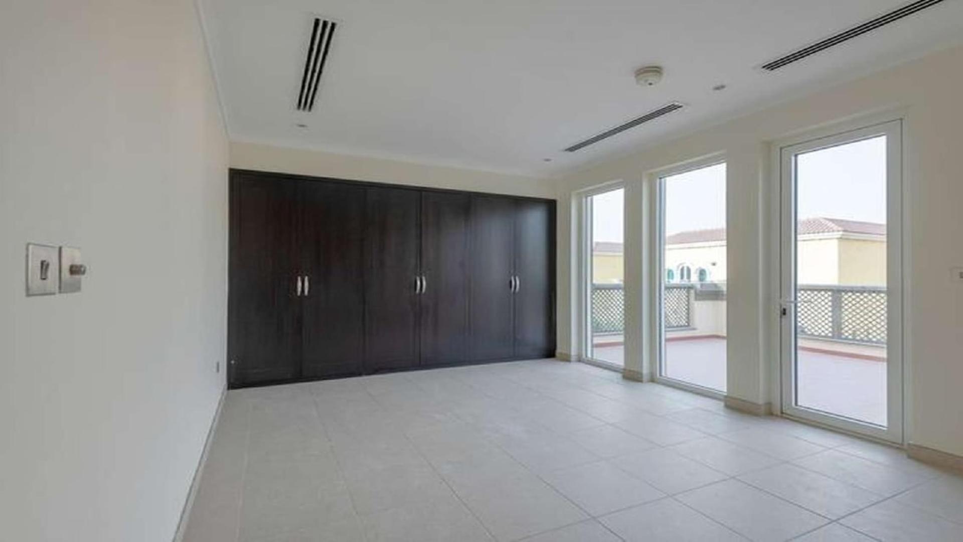 "Spacious 3-bedroom villa exterior in Jumeirah Park, Regional community, available for rent.",Spacious bedroom with large windows and built-in wardrobe in Jumeirah Park villa for rent