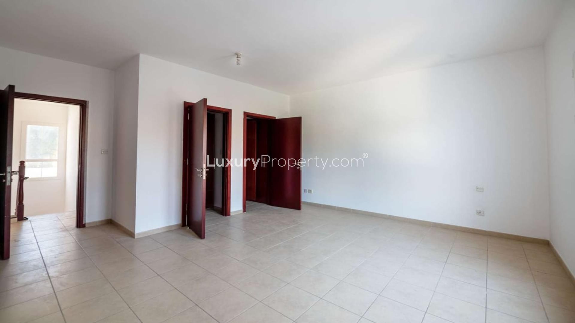 Empty room in 3-bedroom Al Reem villa, Arabian Ranches, featuring tiled floors and wooden doors