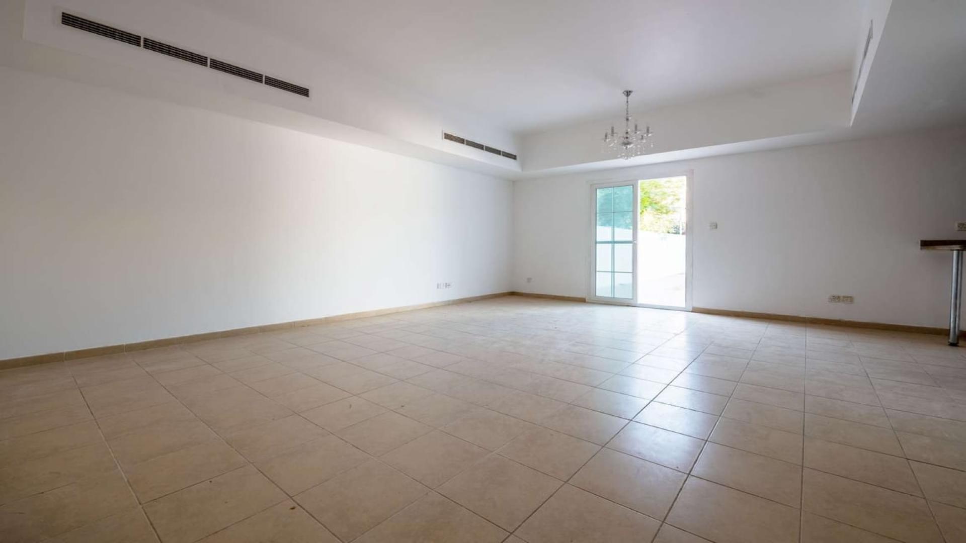 "Spacious balcony view of Al Reem villa with lush greenery, Arabian Ranches community.",Spacious living room in Al Reem 3M Villa, Arabian Ranches, with tiled floors and natural light