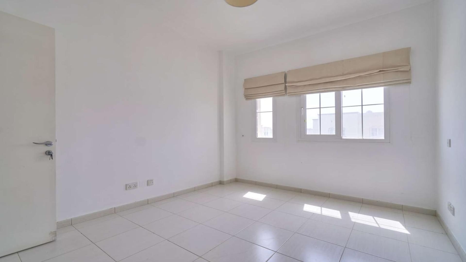 Empty bright room with tiled floor and large window in The Springs villa