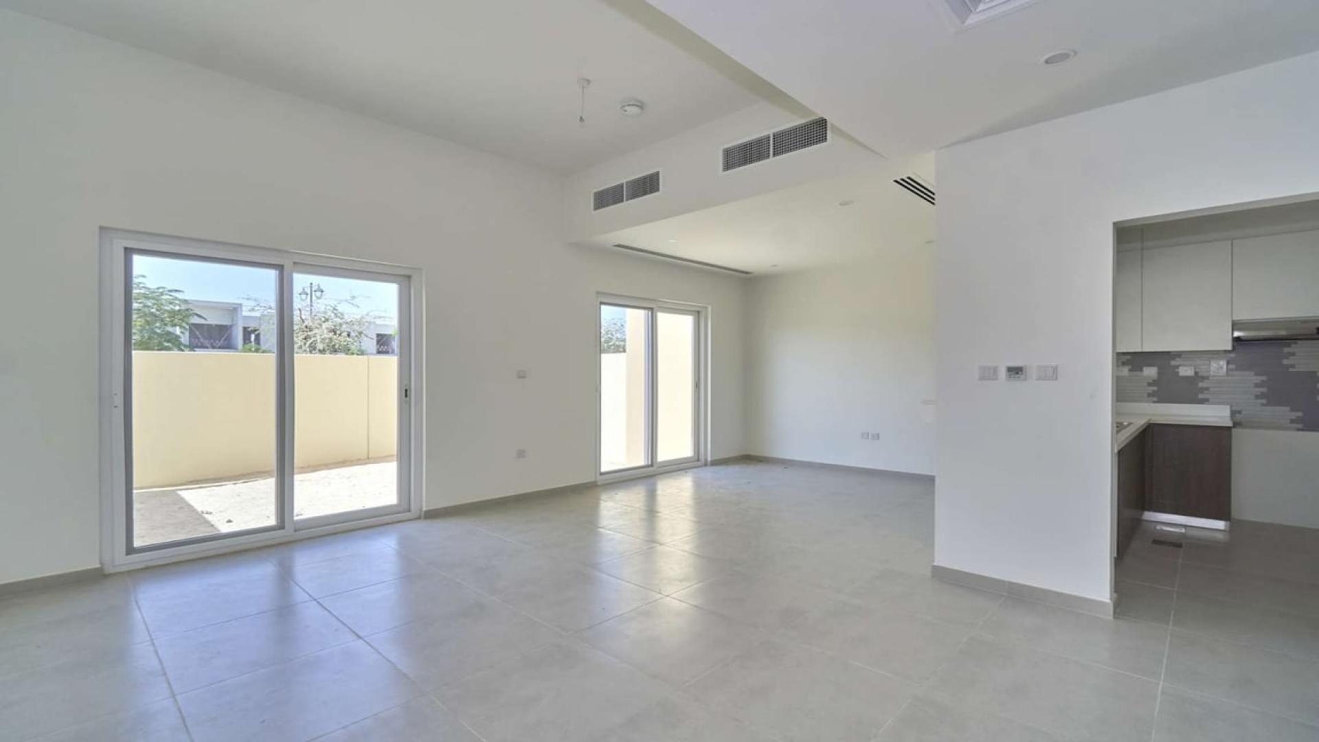 Spacious living area in Villanova villa for rent, Dubai Land, with modern kitchen view