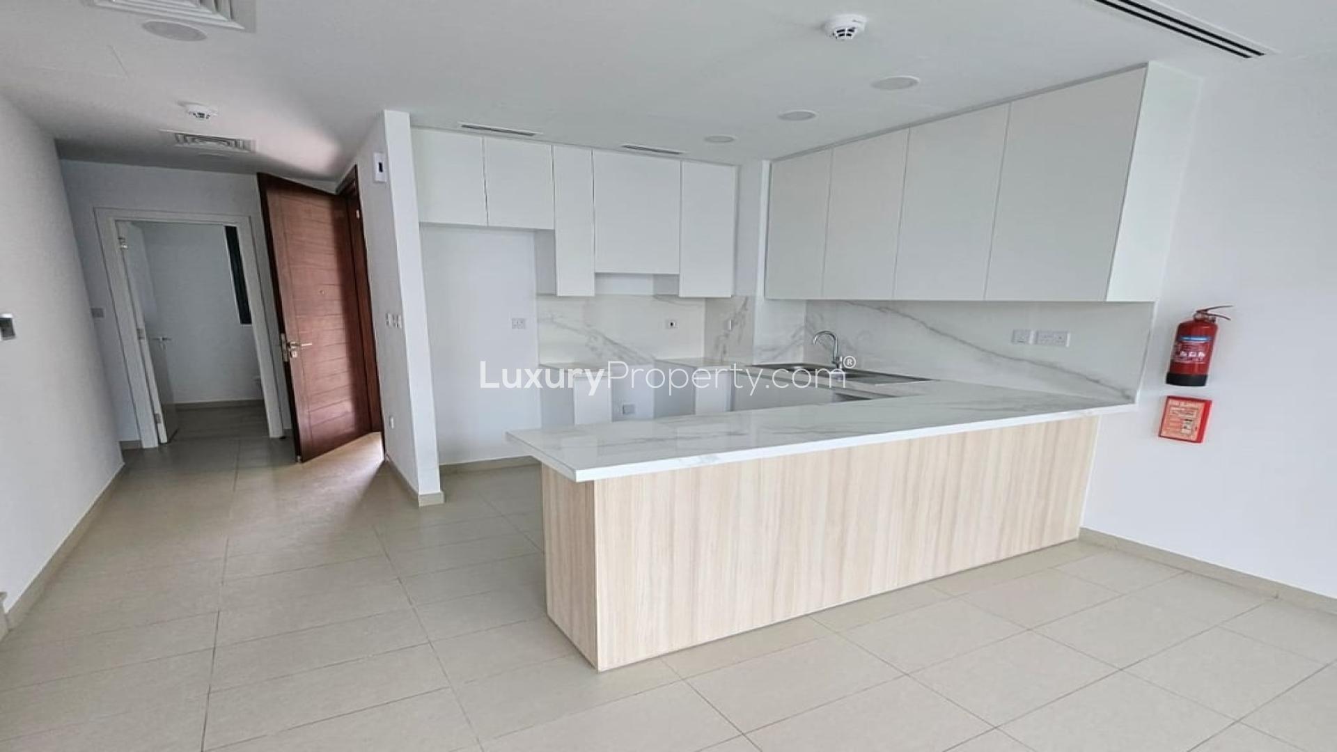 Spacious living area with large windows overlooking landscaped garden in Cherrywoods villa, Dubai Land