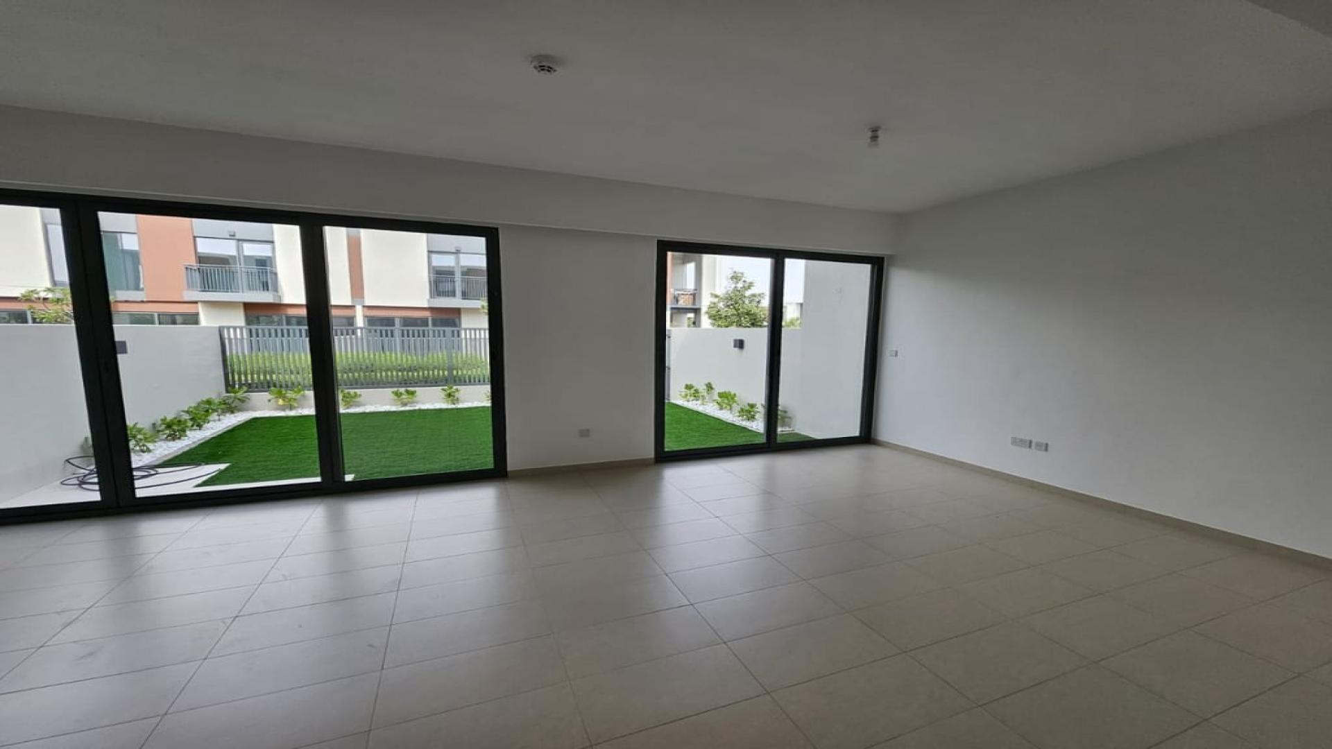 Spacious living room with garden view in Cherrywoods villa, Dubai Land, for rent