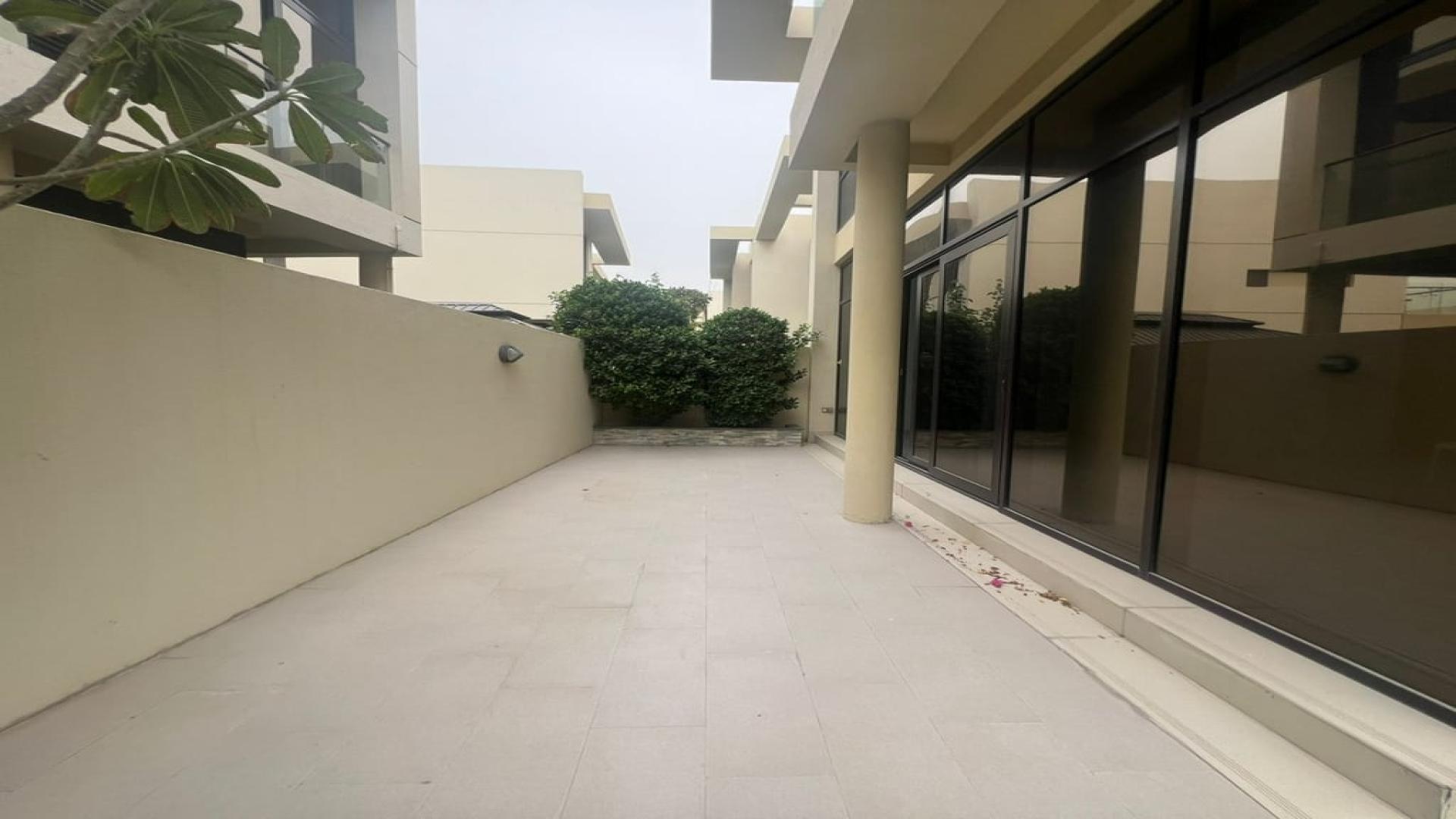 Spacious backyard of Richmond villa in Damac Hills, lush greenery, ideal for family gatherings