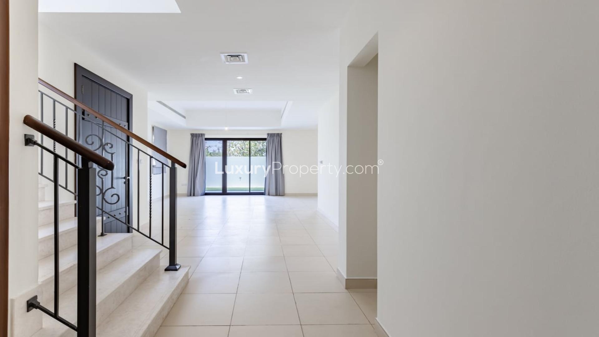 Spacious living area in Mira villa, open layout with staircase and kitchen view