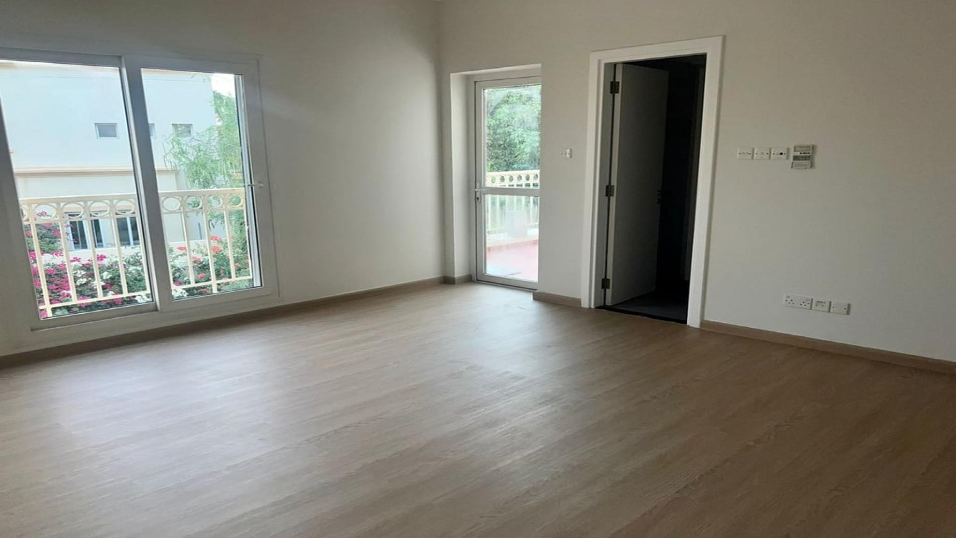 Empty room with wooden flooring and balcony view in Springs 12 villa, Dubai