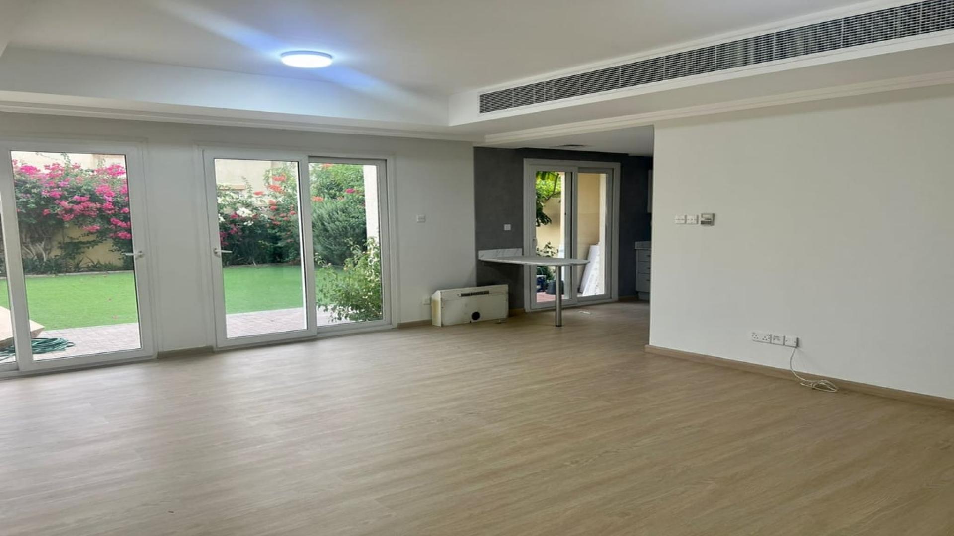 Upgraded Springs 12 villa garden with lush greenery and vibrant flowers in Dubai