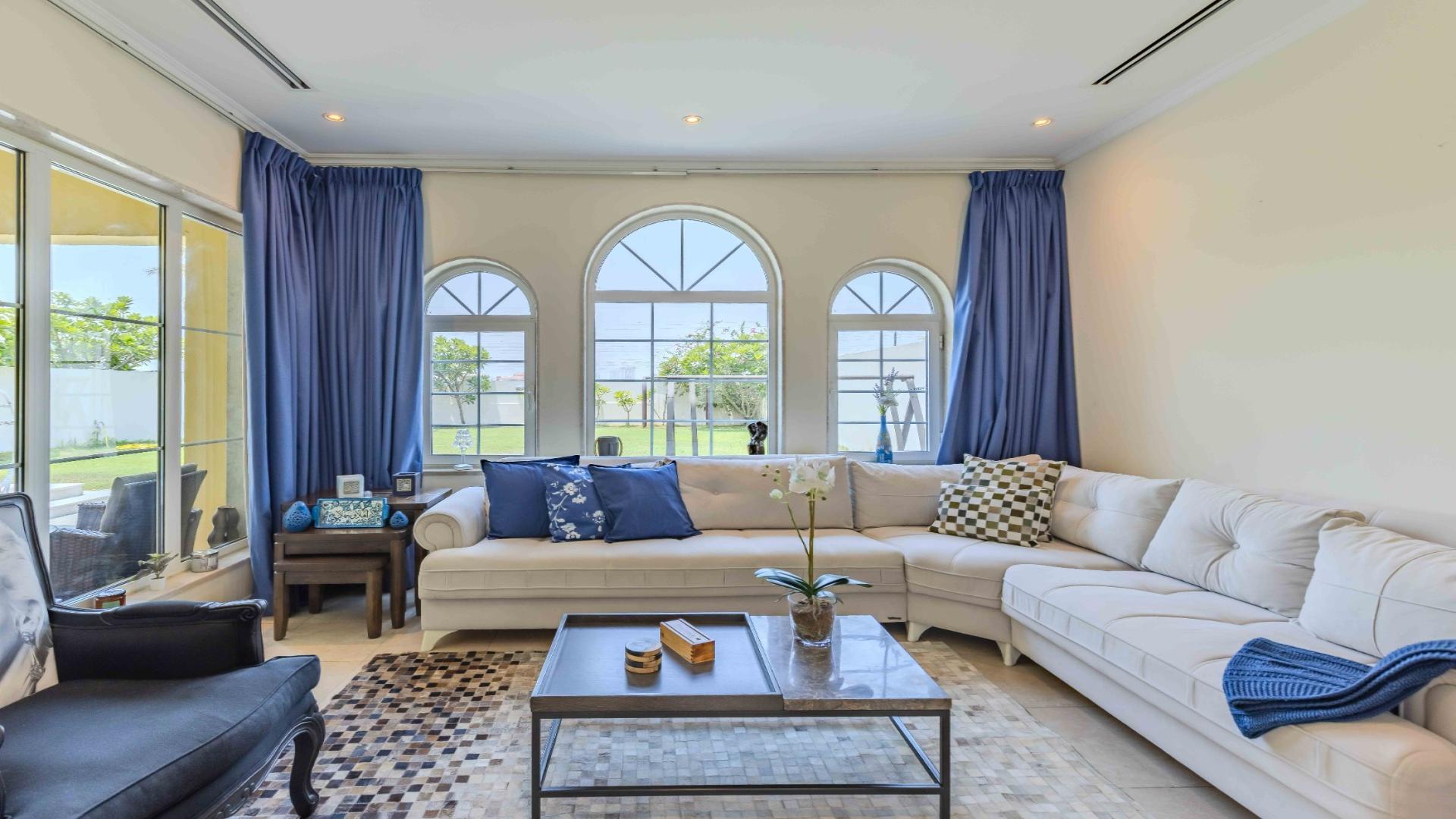 Elegant living room in Jumeirah Park villa with large windows and cozy seating area