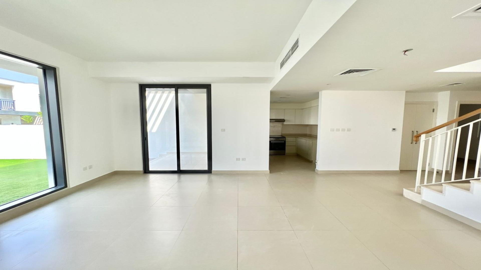 Bright living area in Maple at Dubai Hills Estate villa, featuring modern staircase design
