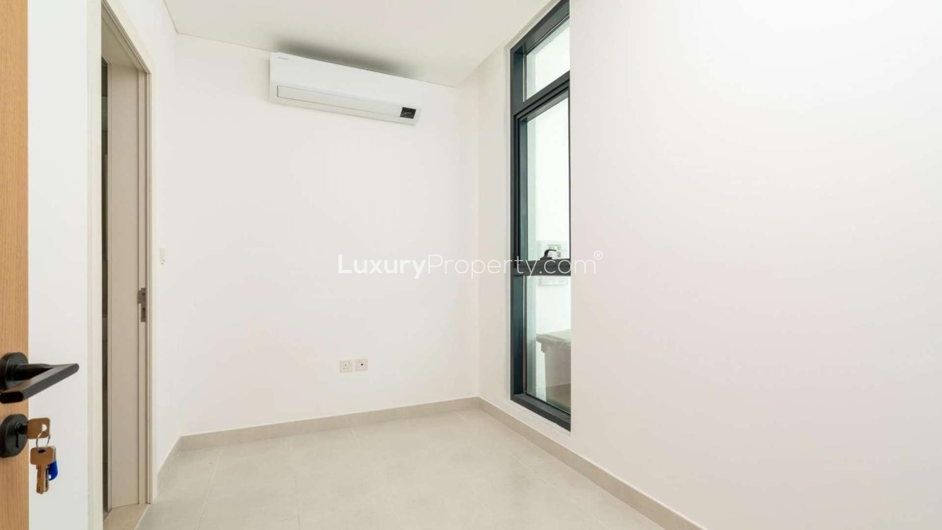 "Spacious living area with garden view in Jumeirah Luxury townhouse, Jumeirah Golf Estates.",Bright bedroom with large window in Jumeirah Luxury townhouse, Jumeirah Golf Estates