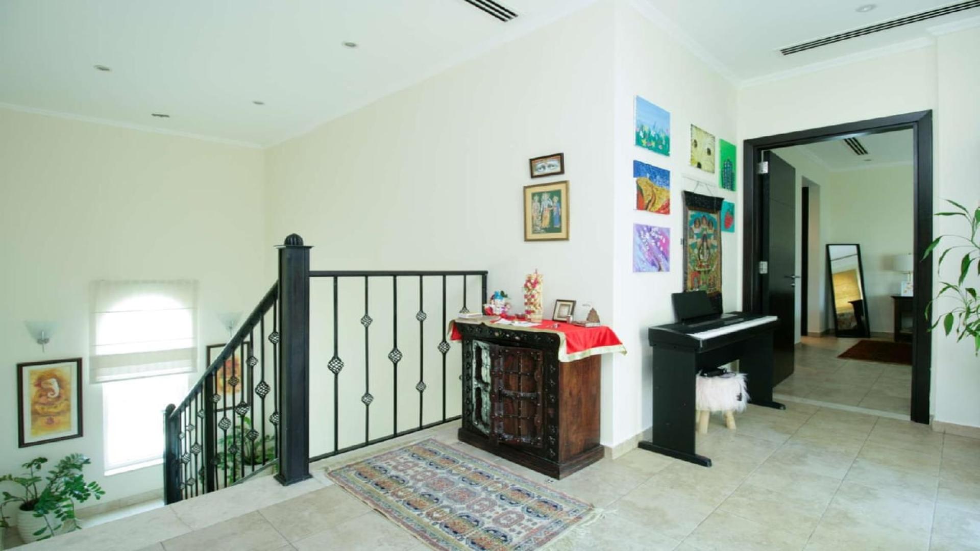 Modern kitchen in 3-bedroom Legacy Villa, Jumeirah Park, featuring dark cabinets and ample light
