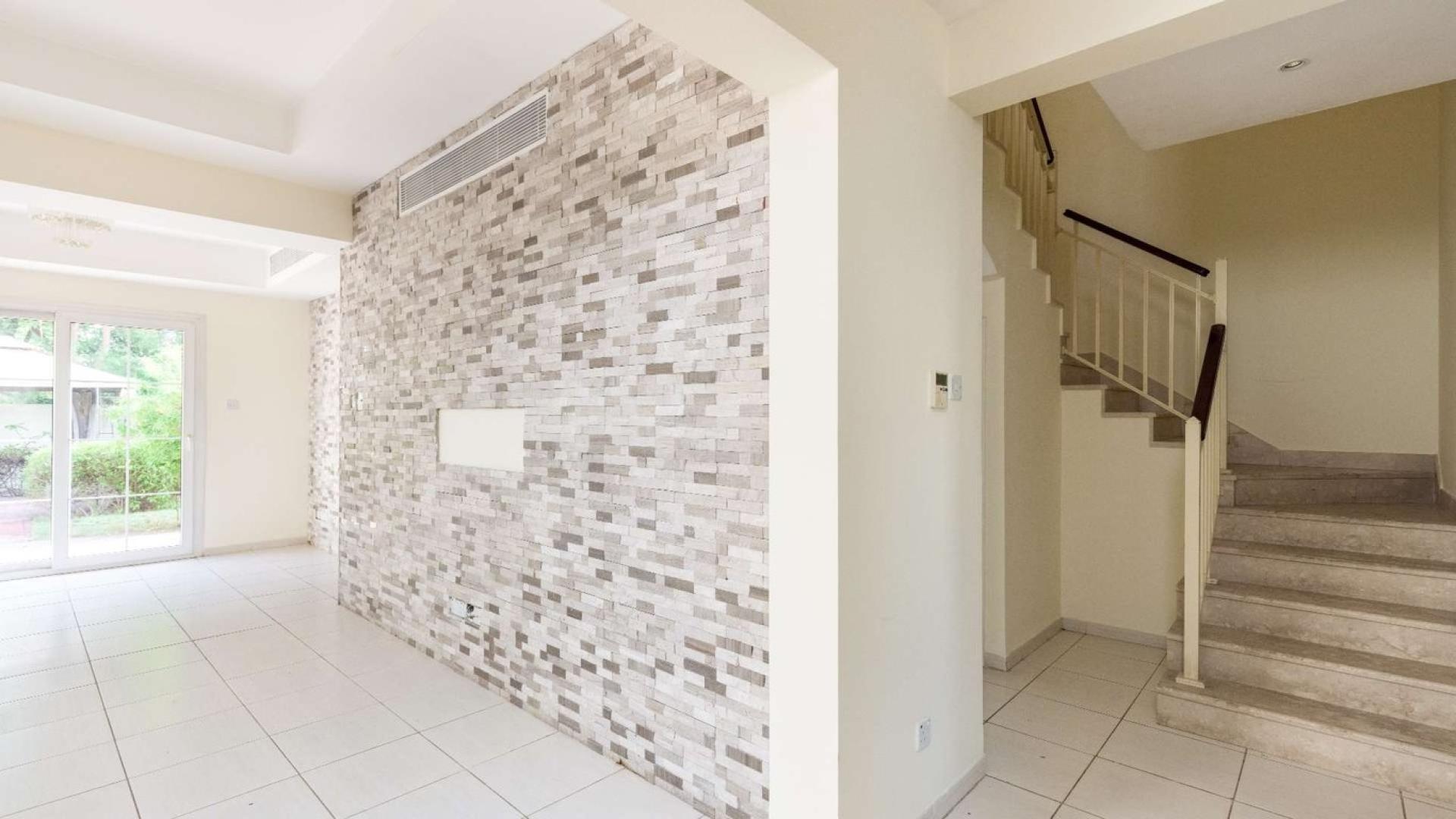 "Balcony view of lush greenery at spacious villa in The Springs community.",Interior view of spacious villa in The Springs with tiled wall and staircase