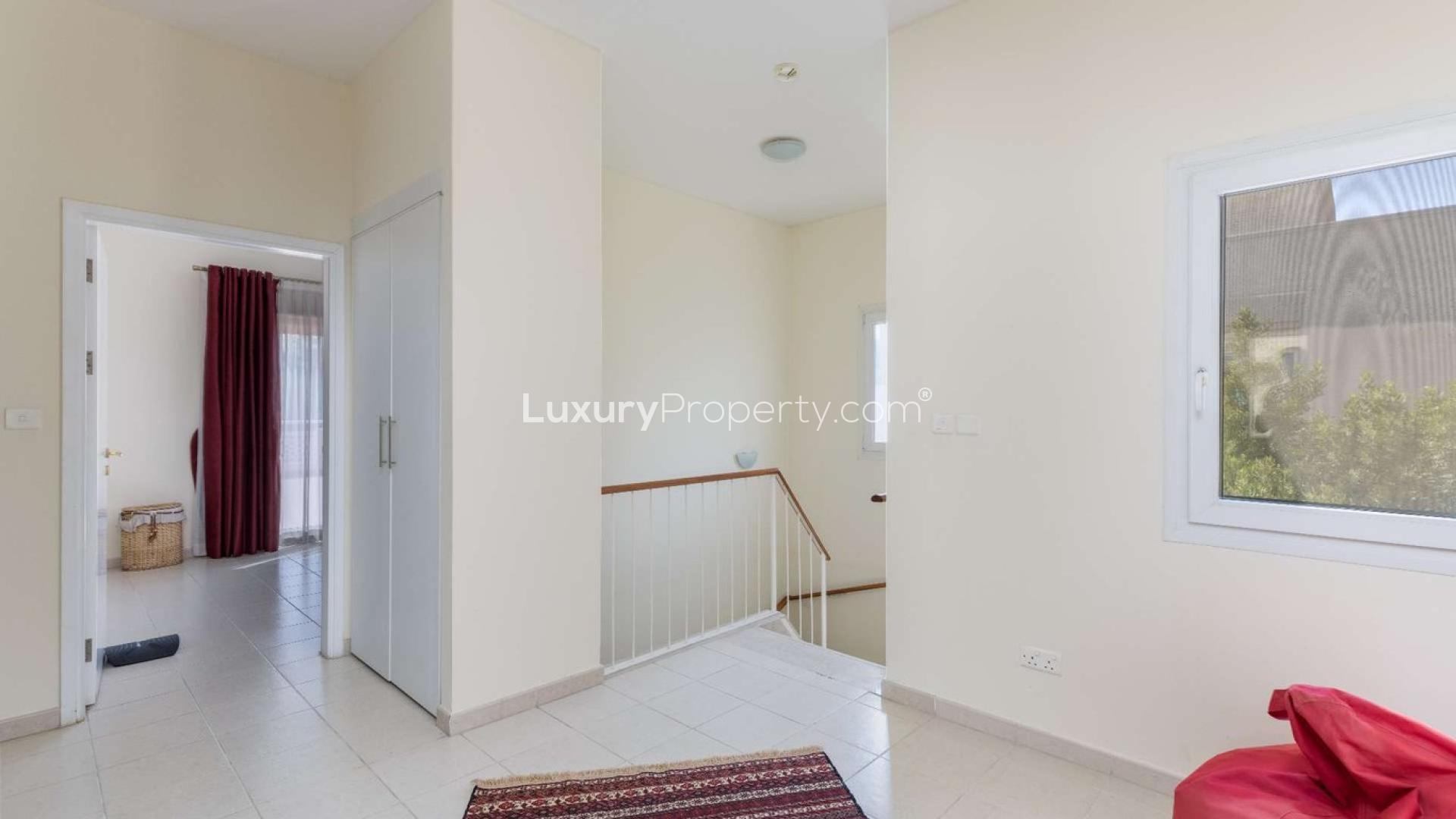 Cozy living room in single row villa, Meadows 9, with garden view through large windows