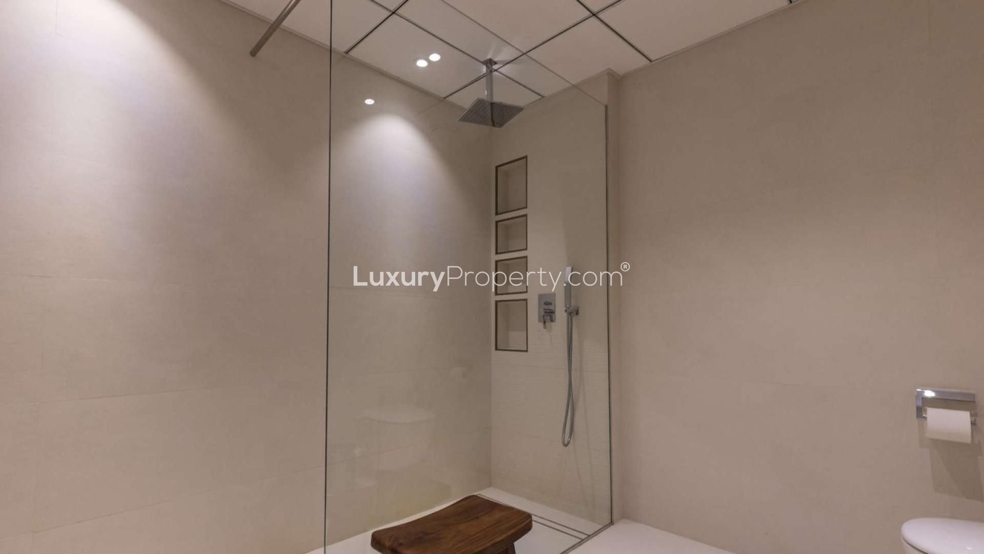 "Spacious living area in Al Sahab 1 villa, Dubai Marina, featuring modern decor and hardwood floors.",Modern bathroom with glass shower in Al Sahab 1 villa, Dubai Marina