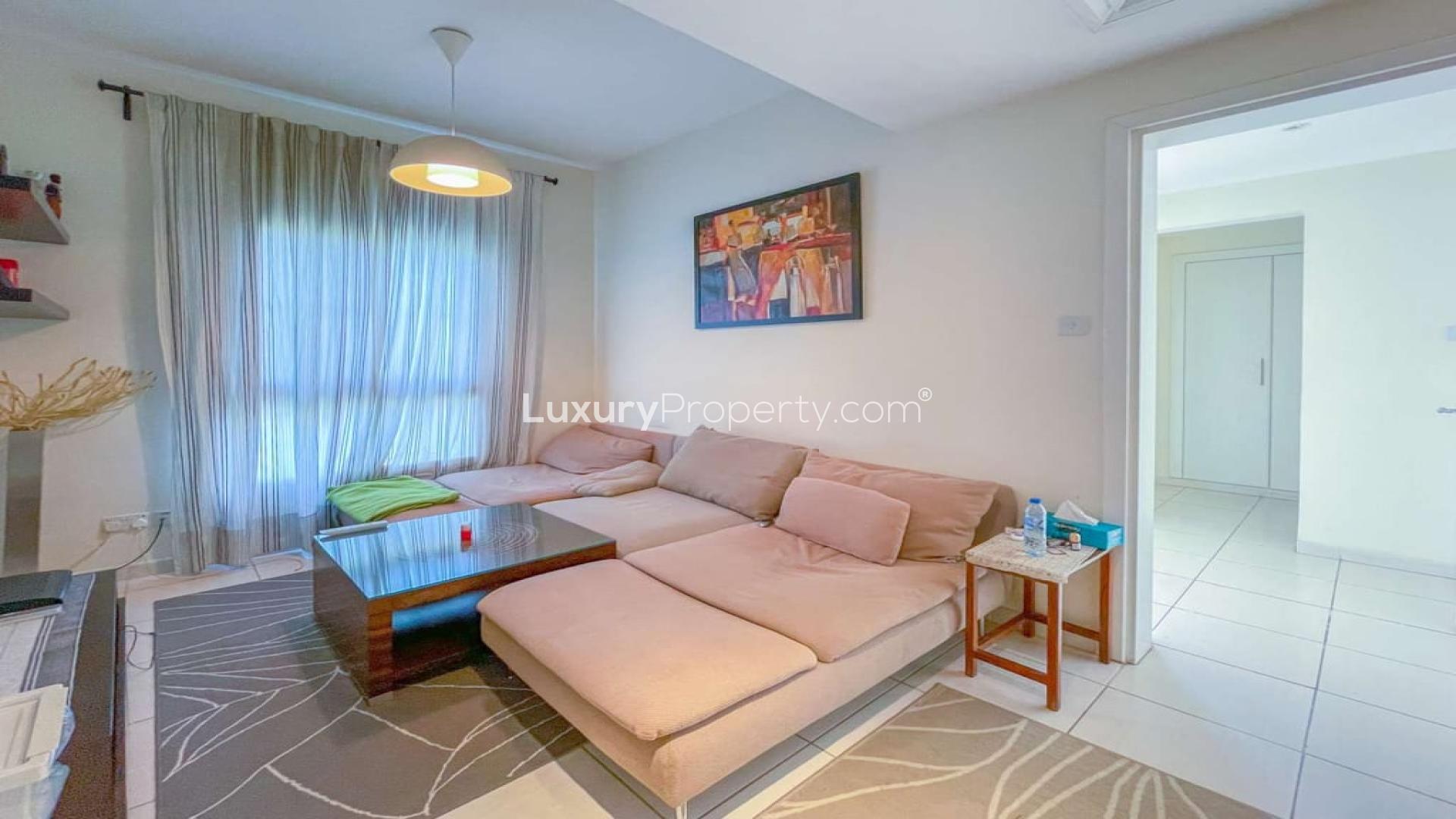 Living room in three-bed villa, The Springs, with modern decor and cozy seating area