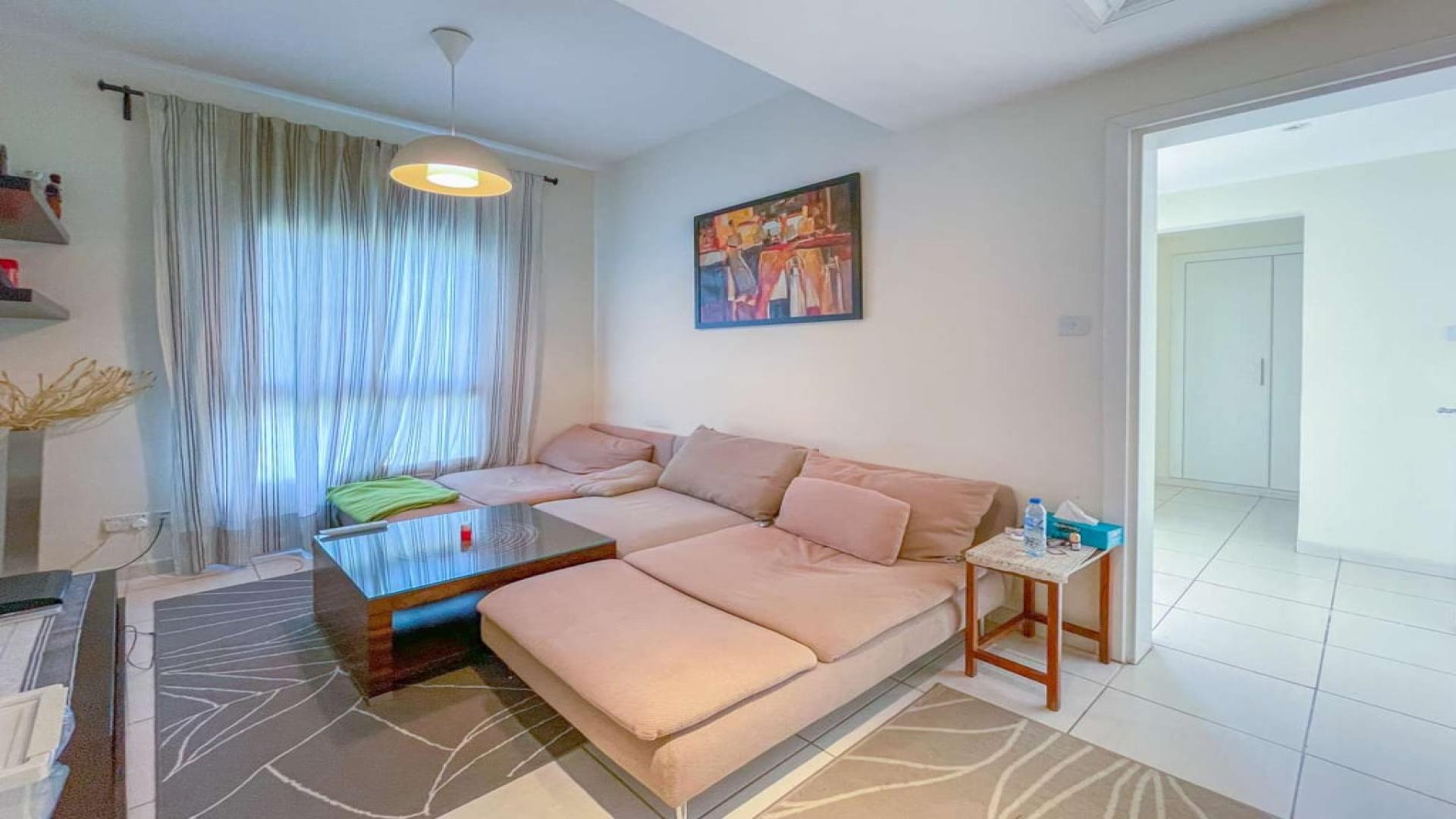 Living room in three-bed villa, The Springs, with modern decor and cozy seating area