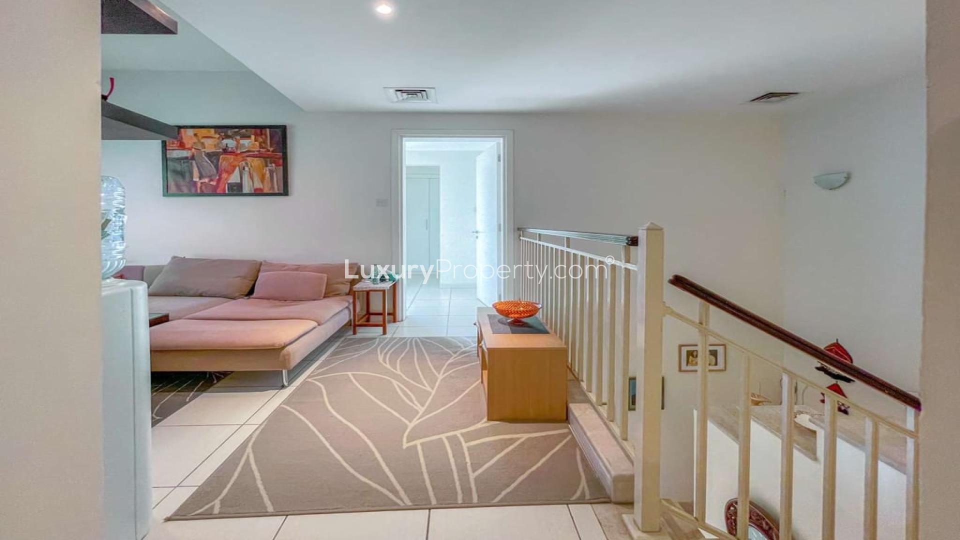 Three-bed villa garden with lush greenery and stunning lake views in The Springs