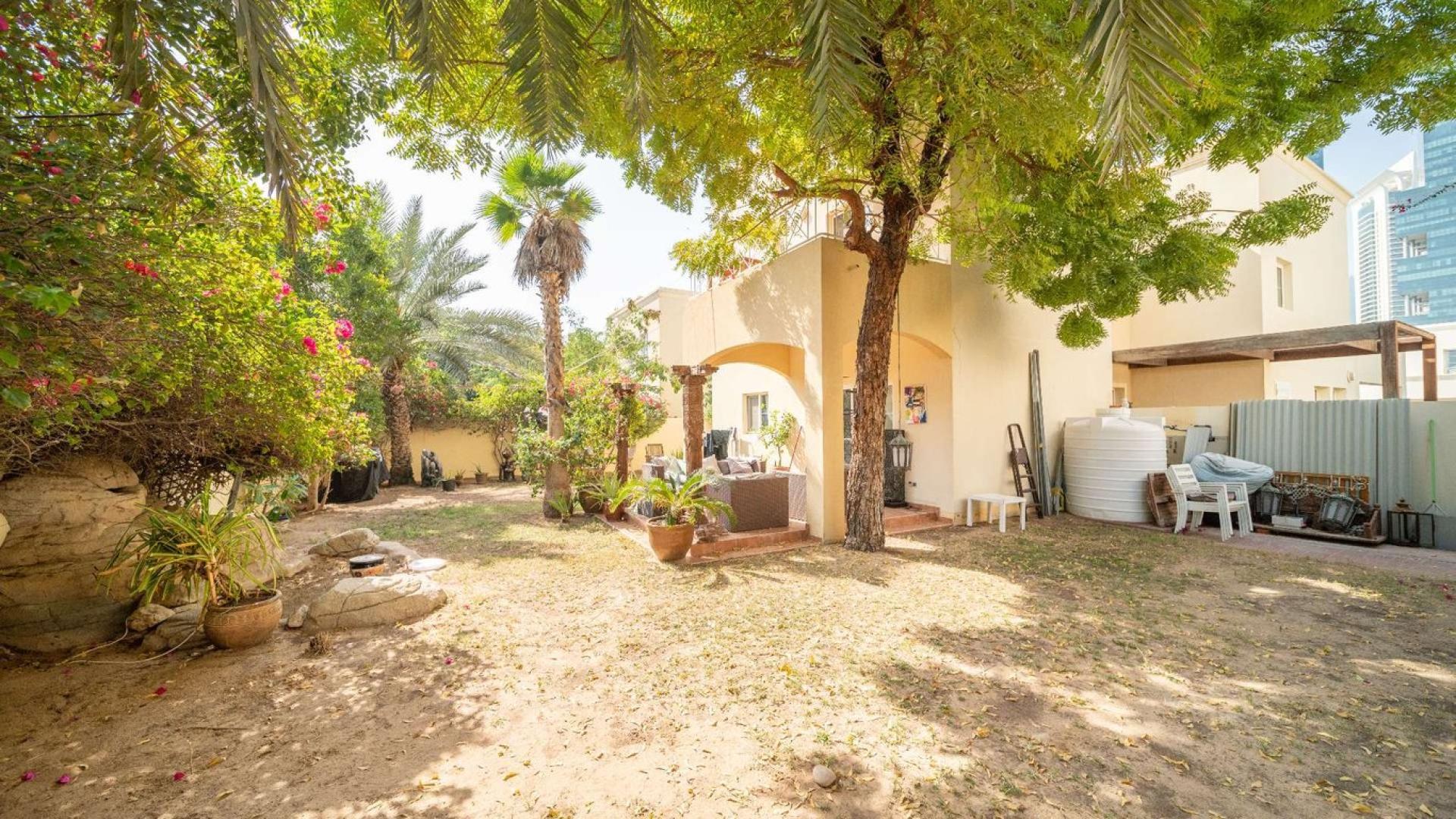 Villa exterior with garden, patio furniture, and greenery in Meadows 1, close to park