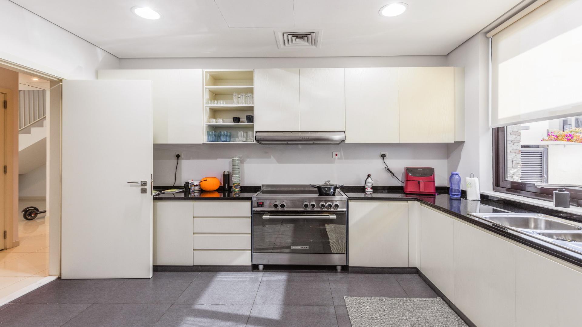 Modern kitchen in upgraded single-row villa, The Field, Damac Hills. Spacious with natural light