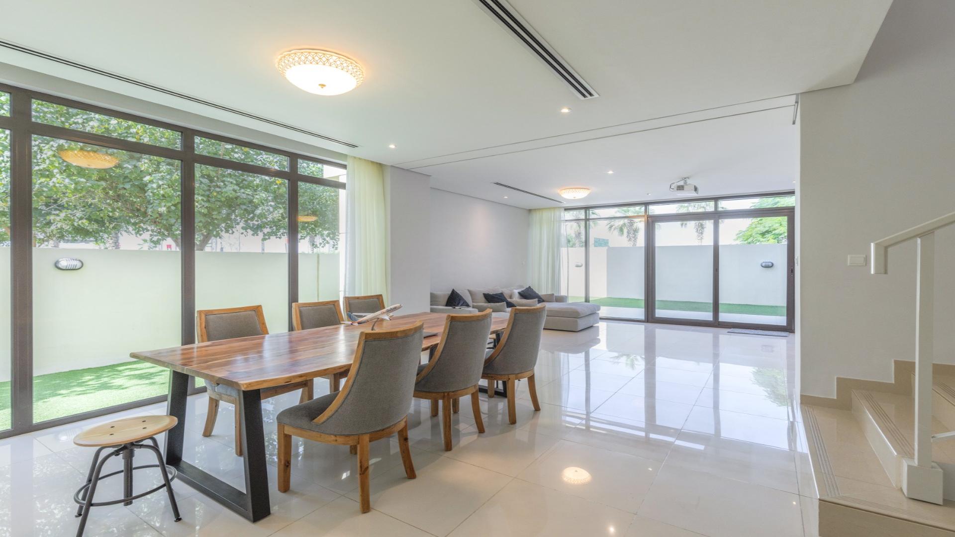 Upgraded villa exterior with patio and lawn in The Field, Damac Hills, for sale