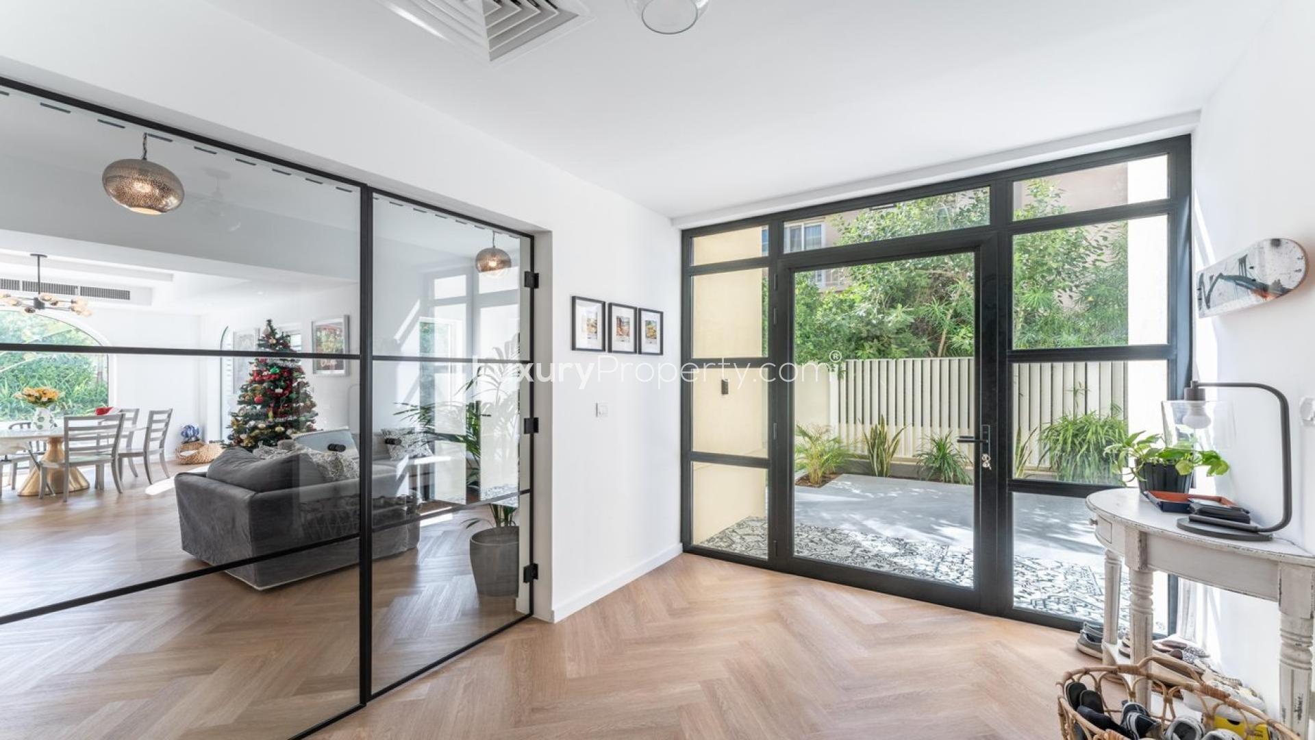 "Villa with private pool and patio in Maeen, The Lakes community, available for rent.",Bright villa interior with glass doors, garden view, open living area in Maeen, The Lakes