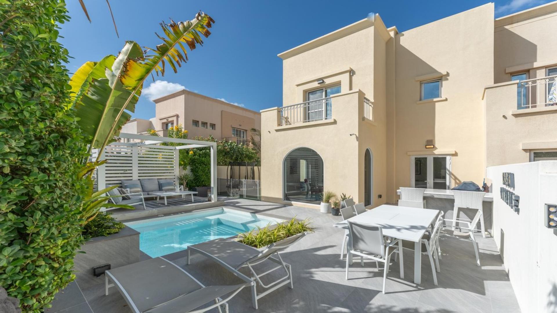 Living room with modern decor in Maeen villa, The Lakes, featuring blue accent wall