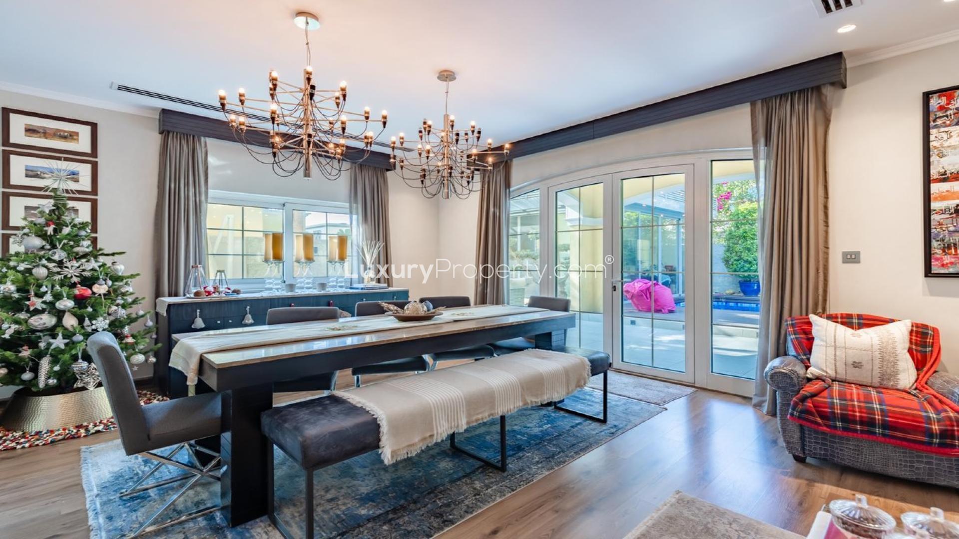 Dining room in upgraded Jumeirah Park villa, featuring elegant chandeliers and garden view