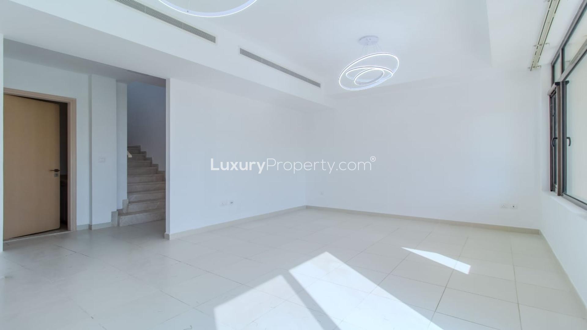 "Spacious backyard of 3-bedroom villa for sale in Mira Oasis, Reem community.",Spacious living area with modern lighting in Mira Oasis villa, Reem community, for sale