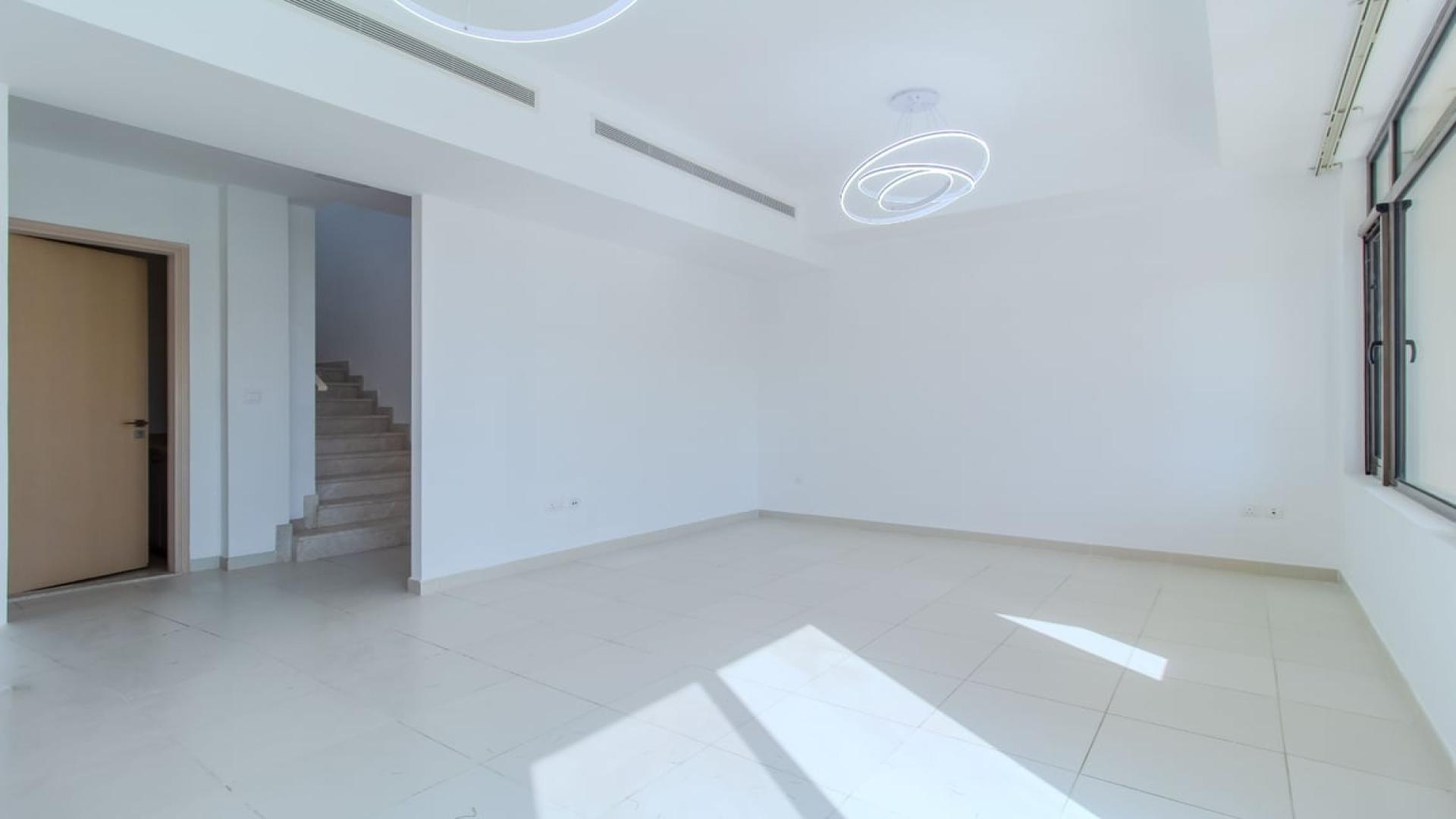 "Spacious backyard of 3-bedroom villa for sale in Mira Oasis, Reem community.",Spacious living area with modern lighting in Mira Oasis villa, Reem community, for sale