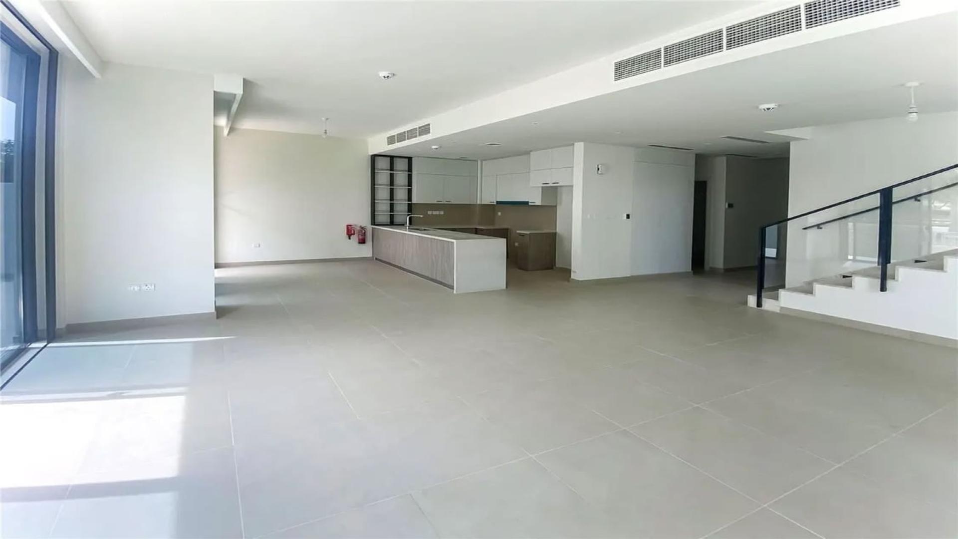 N/A,Open-plan living area in Dubai Hills Estate villa with modern kitchen and staircase